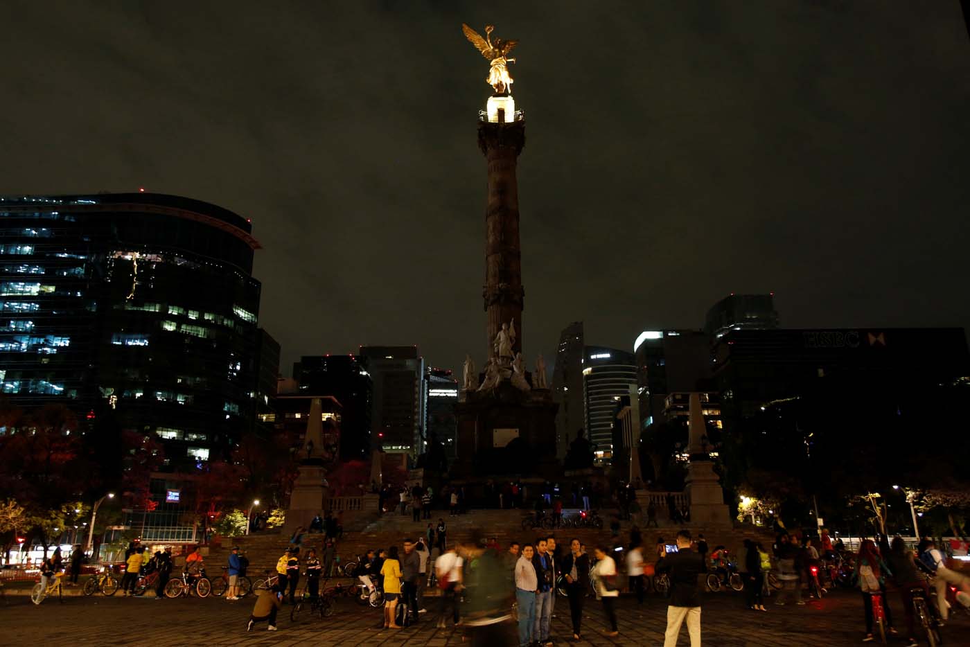 People stand by "Angel de la Independencia" monument after the lights were turned off for Earth Hour in Mexico City, Mexico, March 25, 2017. REUTERS/Ginnette Riquelme