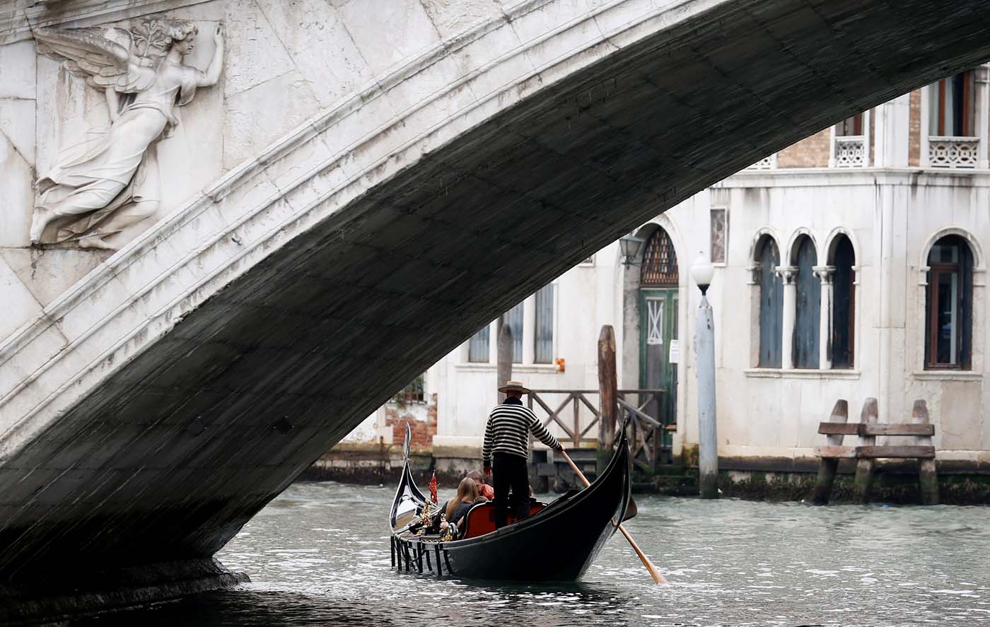 FILE PHOTO: A gondolier rows past the Rialto bridge in Venice, Italy October 13, 2013. REUTERS/Stefano Rellandini/File Photo