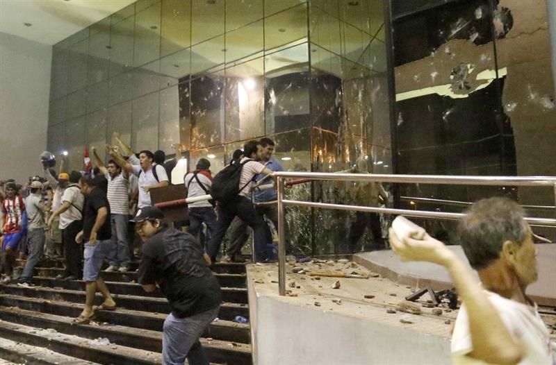 Manifestantes atacan hoy, viernes 31 de marzo de 2017, la sede del Congreso Nacional en Asunción (Paraguay). EFE