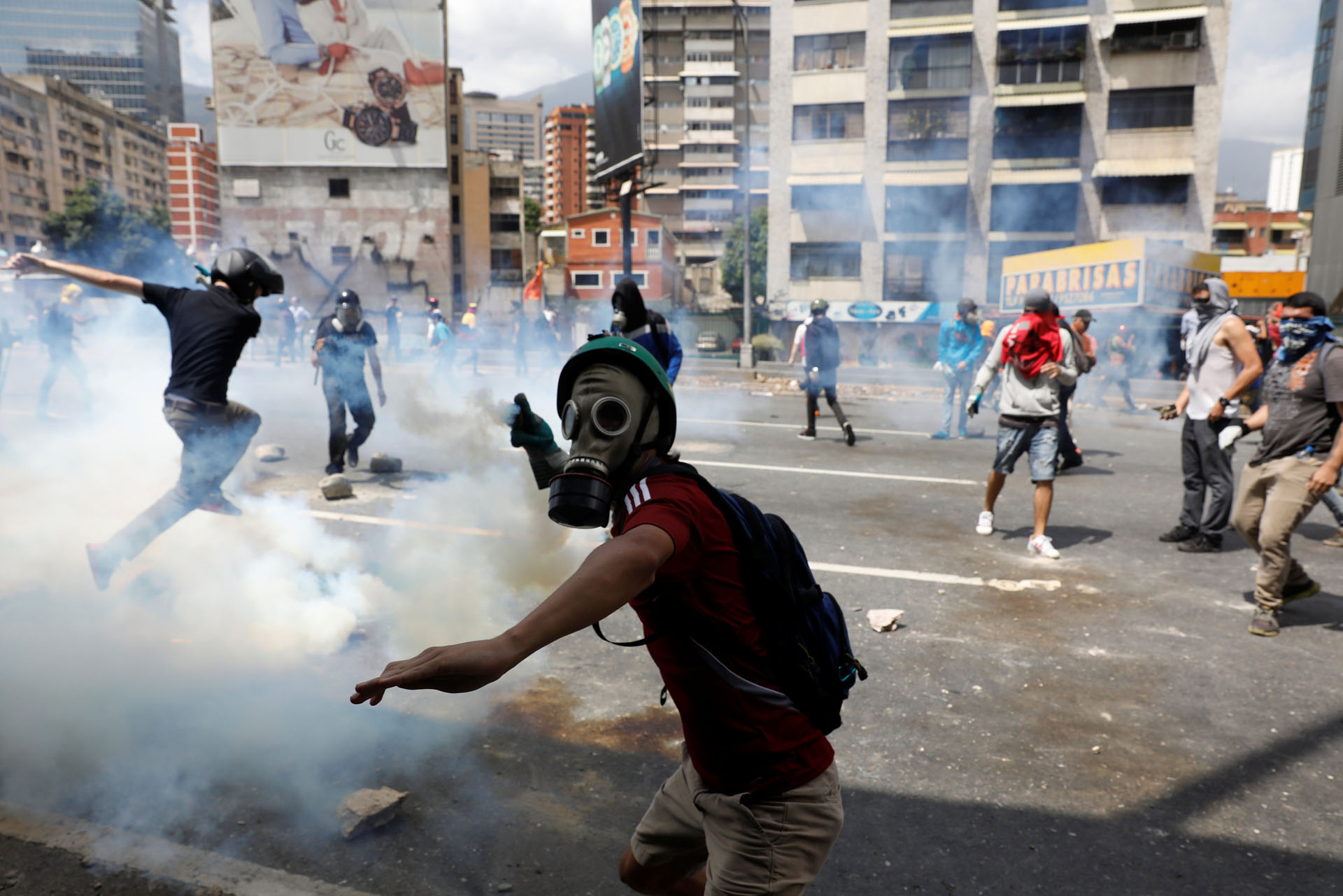 A demonstrator throws a tear gas canister back to policemen during an opposition rally in Caracas, Venezuela April 6, 2017. REUTERS/Carlos Garcia Rawlins