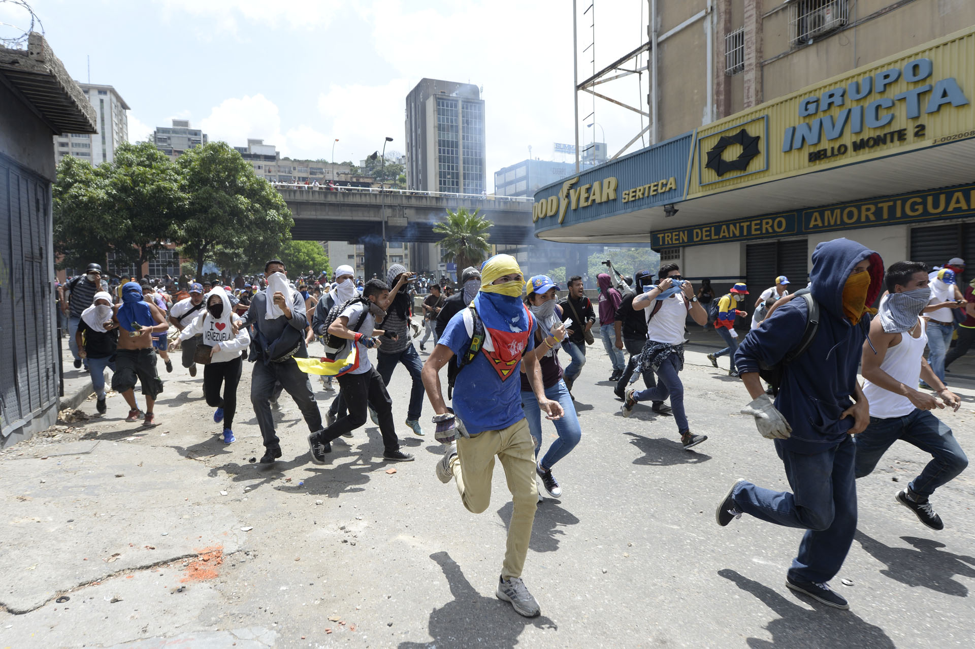 Venezuelan opposition activists run during protests against the government of President Nicolas Maduro on April 6, 2017 in Caracas. The center-right opposition vowed fresh street protests -after earlier unrest left dozens of people injured - to increase pressure on Maduro, whom they blame for the country's economic crisis. / AFP PHOTO / FEDERICO PARRA