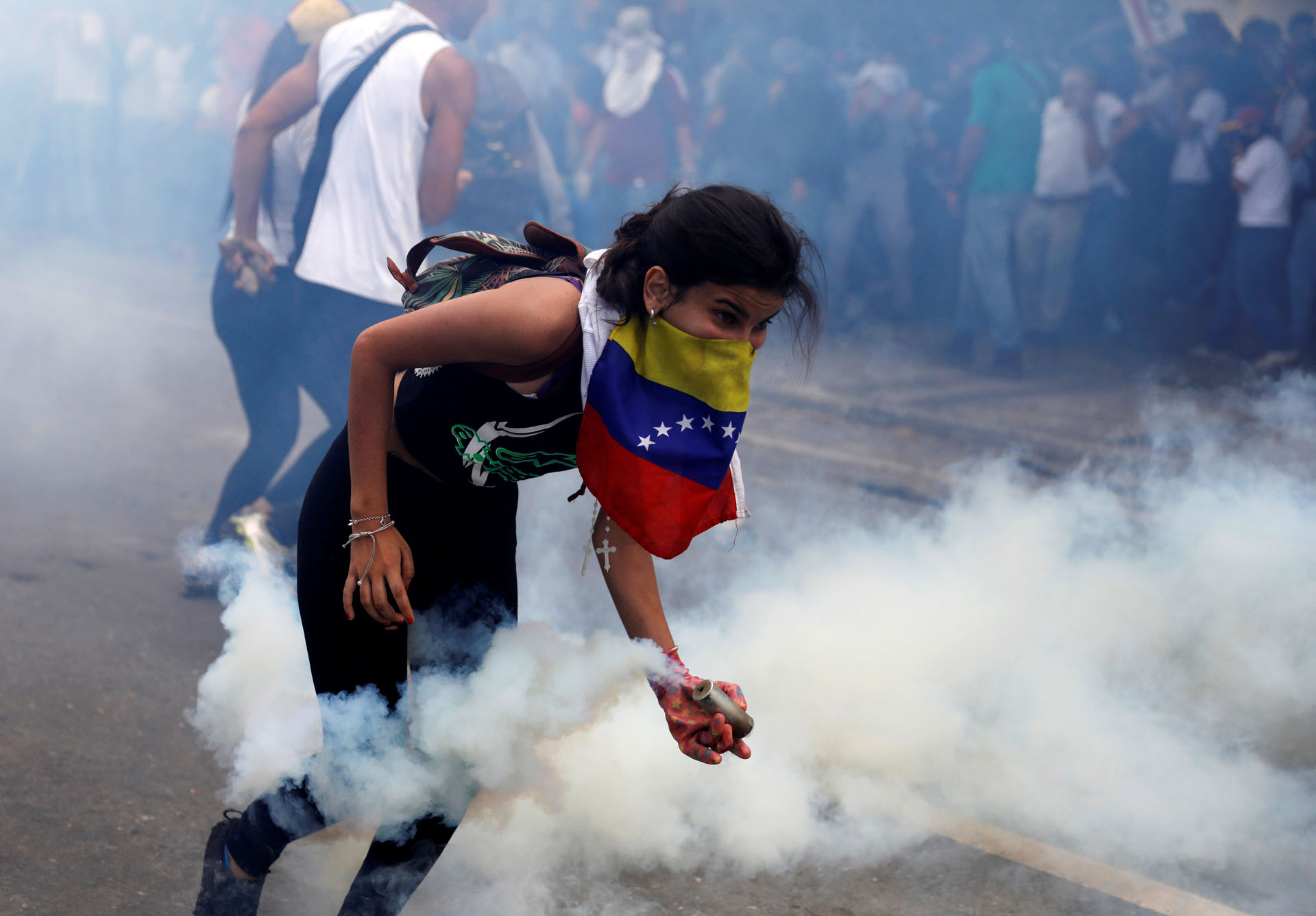 A demonstrator picks up a tear gas canister during clashes with security forces at an opposition rally in Caracas, Venezuela, April 6, 2017. REUTERS/Carlos Garcia Rawlins