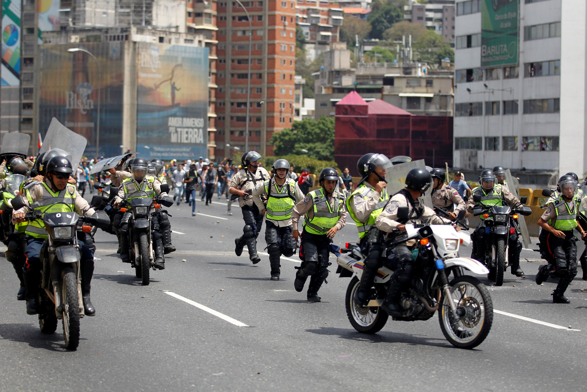 Police withdraw as demonstrators run toward them during an opposition rally in Caracas, Venezuela, April 6, 2017. REUTERS/Christian Veron