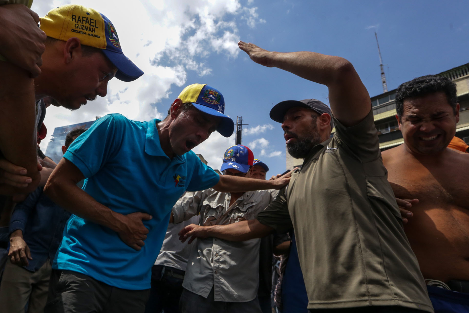 CAR01. CARACAS (VENEZUELA), 06/04/2017 - El líber opositor venezolano Henrique Capriles (c) es afectado por gases lacrimógenos durante una manifestación contra el gobierno venezolano hoy, jueves 6 de abril de 2017, en Caracas (Venezuela). La alianza de partidos Mesa de la Unidad Democrática (MUD), contraria al Gobierno de Nicolás Maduro, aseguró hoy que los venezolanos se manifestaron este jueves en ocho ciudades de Venezuela en contra de los magistrados del Tribunal Supremo de Justicia (TSJ) a quienes acusan de haber dado un "golpe de Estado". EFE/CRISTIAN HERNÁNDEZ