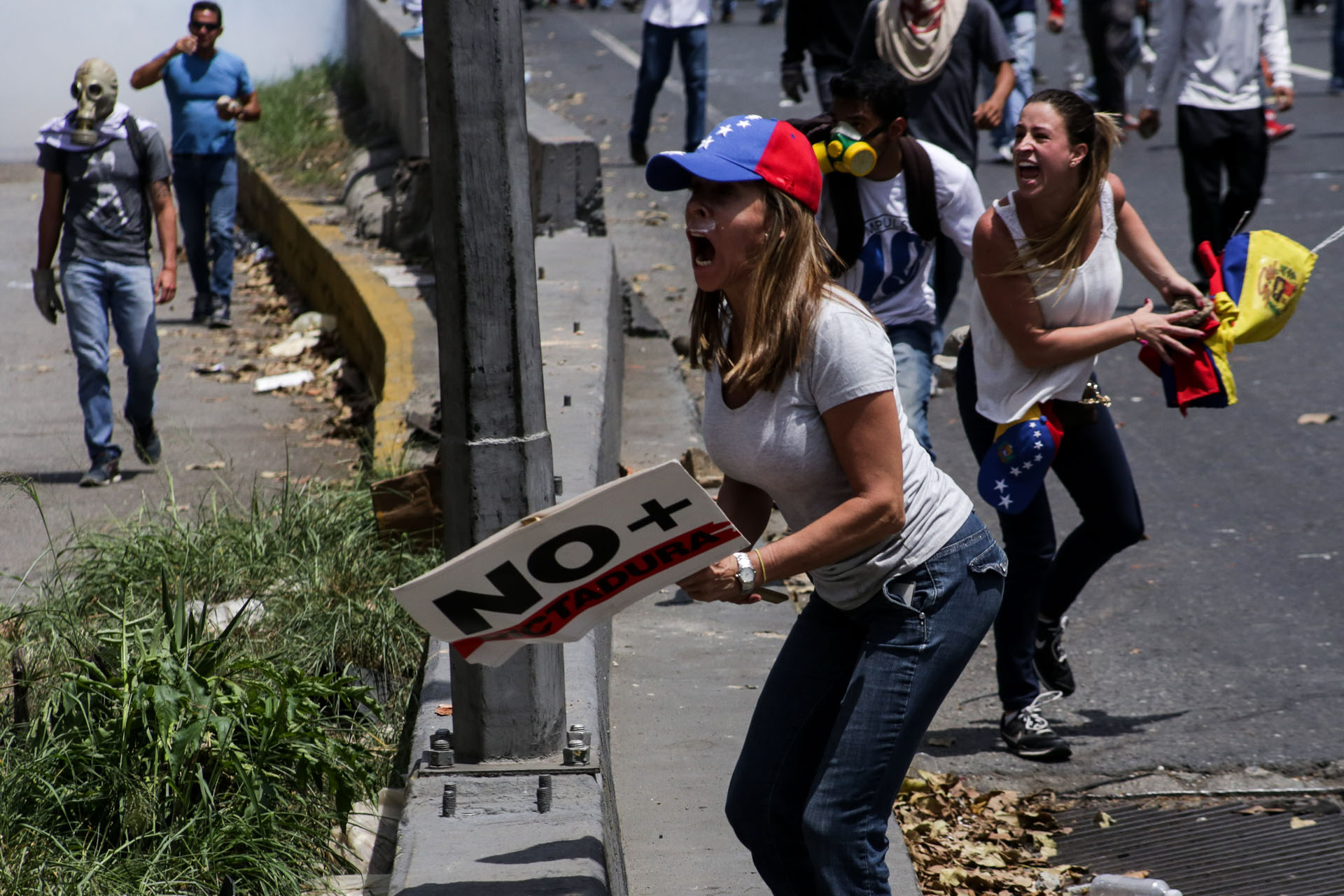 CAR01. CARACAS (VENEZUELA), 06/04/2017 - Un grupo de personas participa en una manifestación de opositores al gobierno de Nicolás Maduro hoy, jueves 6 de abril de 2017, en Caracas (Venezuela). La Policía Nacional Bolivariana (PNB) dispersó hoy con gases lacrimógenos y agua una marcha opositora en Caracas que pretendía llegar hasta la Defensoría del Pueblo para pedir su respaldo al proceso iniciado por el Parlamento contra siete magistrados del Tribunal Supremo de Justicia (TSJ). EFE/CRISTIAN HERNÁNDEZ