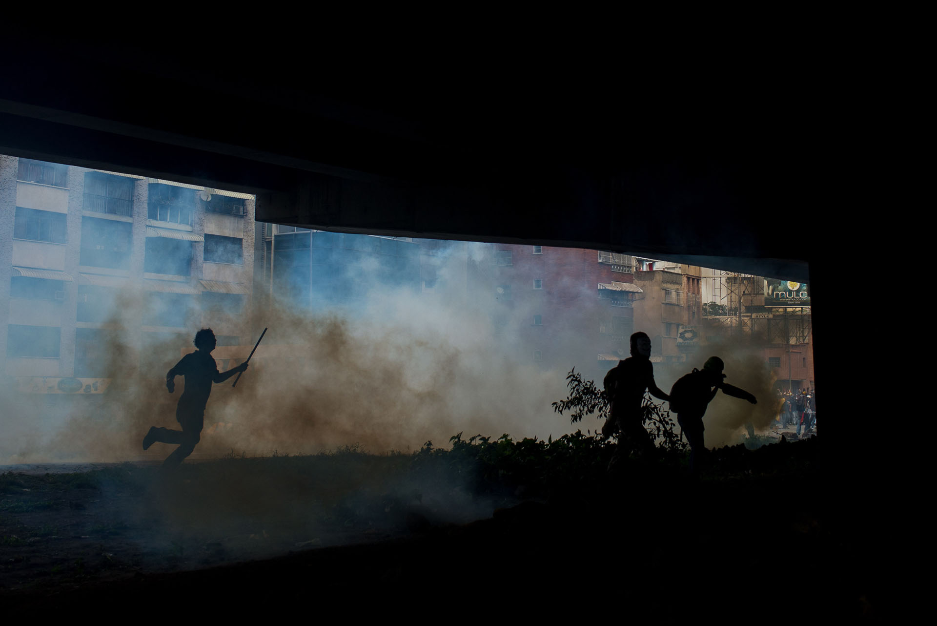 CAR01. CARACAS (VENEZUELA), 06/04/2017 - Manifestantes opositores se cubren del gas lacrimógeno durante una manifestación de opositores al gobierno de Nicolás Maduro hoy, jueves 6 de abril de 2017, en Caracas (Venezuela). Dos fotógrafos de la Agencia EFE en Caracas resultaron hoy heridos durante una protesta opositora en Caracas cuando agentes de los cuerpos de seguridad dispararon a quemarropa contra ellos mientras cubrían gráficamente la manifestación en el este de la capital venezolana. EFE/Manaure Quintero