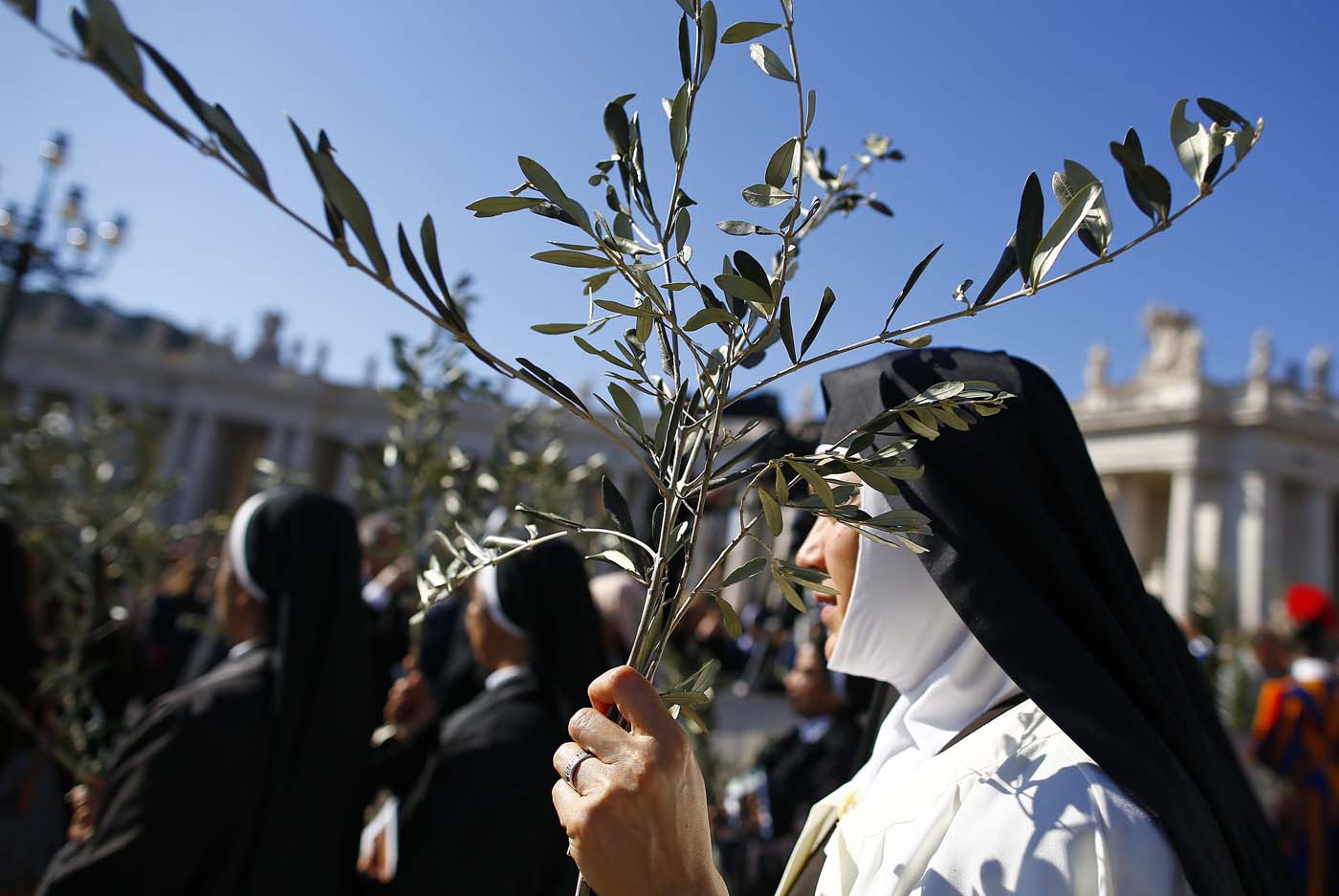 A nun holds a palm during the the Palm Sunday Mass led by Pope Francis in Saint Peter's Square at the Vatican April 9, 2017. REUTERS/Tony Gentile