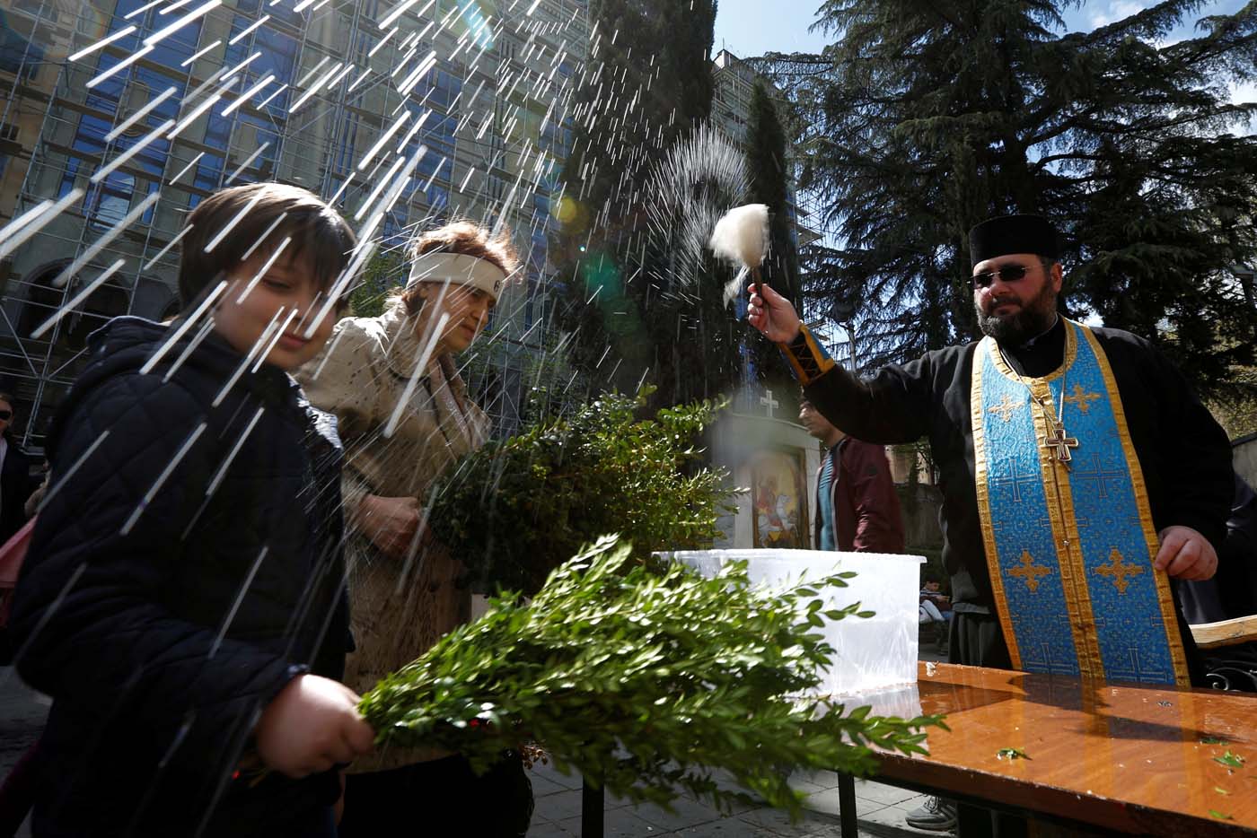 A priest sprays holy water during the Palm Sunday service in Tbilisi, Georgia April 9, 2017. REUTERS/David Mdzinarishvili