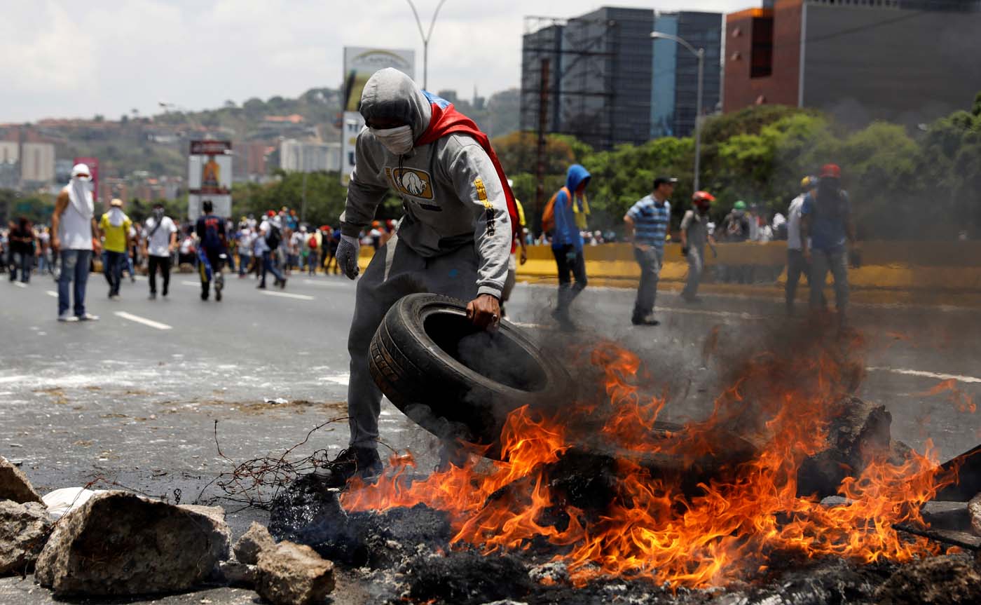 Demonstrators build a fire barricade on a street in Caracas, Venezuela April 10, 2017. REUTERS/Carlos Garcia Rawlins