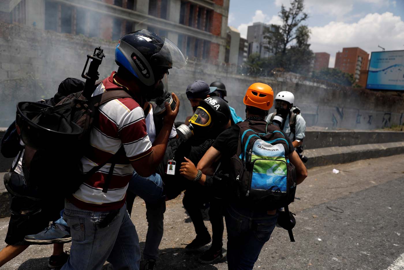A member of the media is helped during a rally against Venezuela's President Nicolas Maduro's government in Caracas, Venezuela April 10, 2017. REUTERS/Carlos Garcia Rawlins