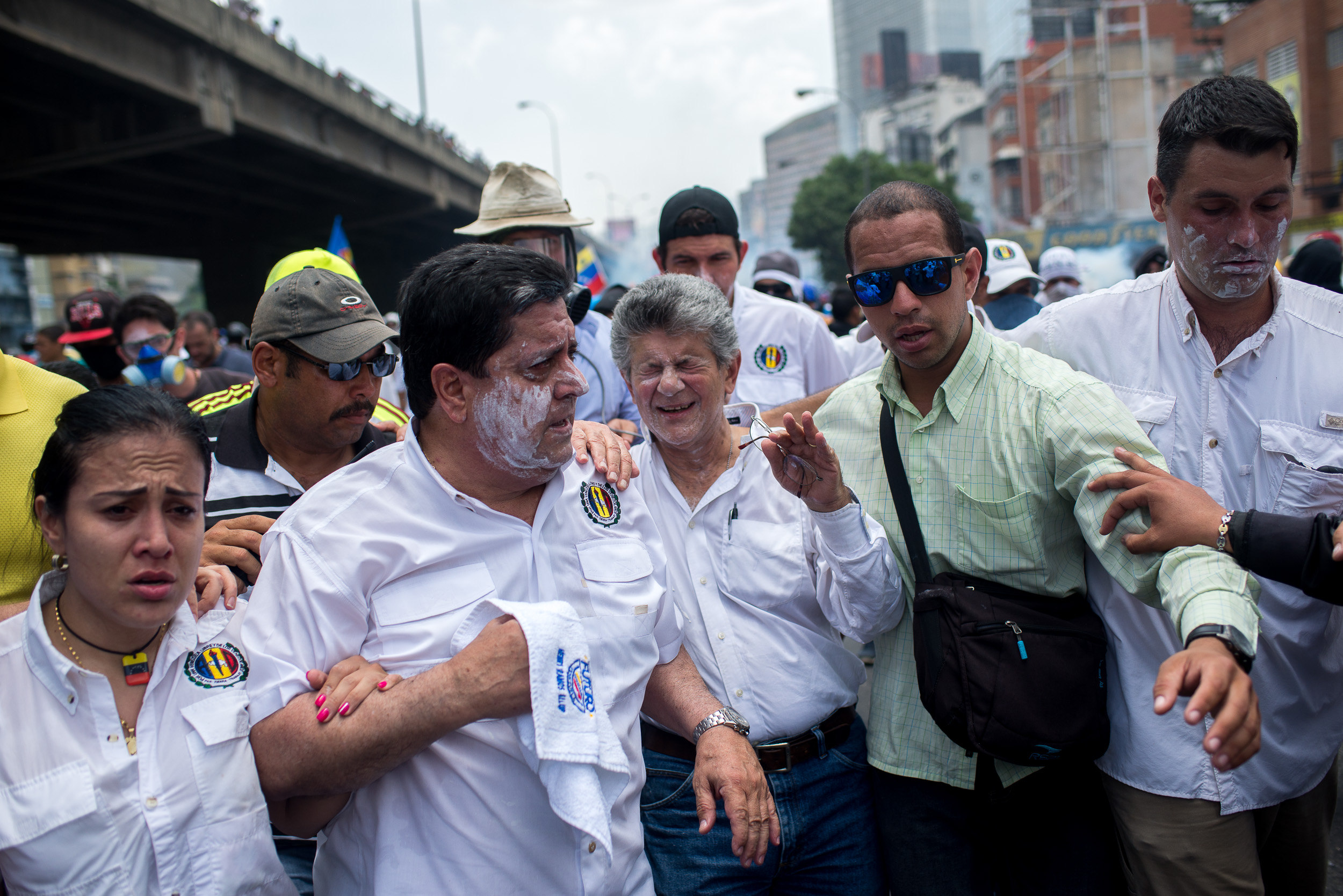 CAR006. CARACAS (VENEZUELA), 19/04/2017.- El expresidente del parlamento y líder opositor Henry Ramos Allup (c) reacciona a los gases lacrimógenos durante una manifestación opositora que intentaba llegar a la Defensoría del Pueblo hoy, miércoles 19 de abril de 2017, en Caracas (Venezuela.). La policía disolvió hoy con gases lacrimógenos una de las marchas opositoras en el centro de Caracas que pretendía llegar a la sede de la Defensoría del Pueblo, mientras que desde otra de las concentraciones antichavistas en esa zona de la ciudad se reportó una persona muerta. Venezuela es escenario el día de hoy de marchas a favor y en contra del Gobierno a las que cada uno de los bandos ha convocado para medir fuerzas en la calle. EFE/Manaure Quintero