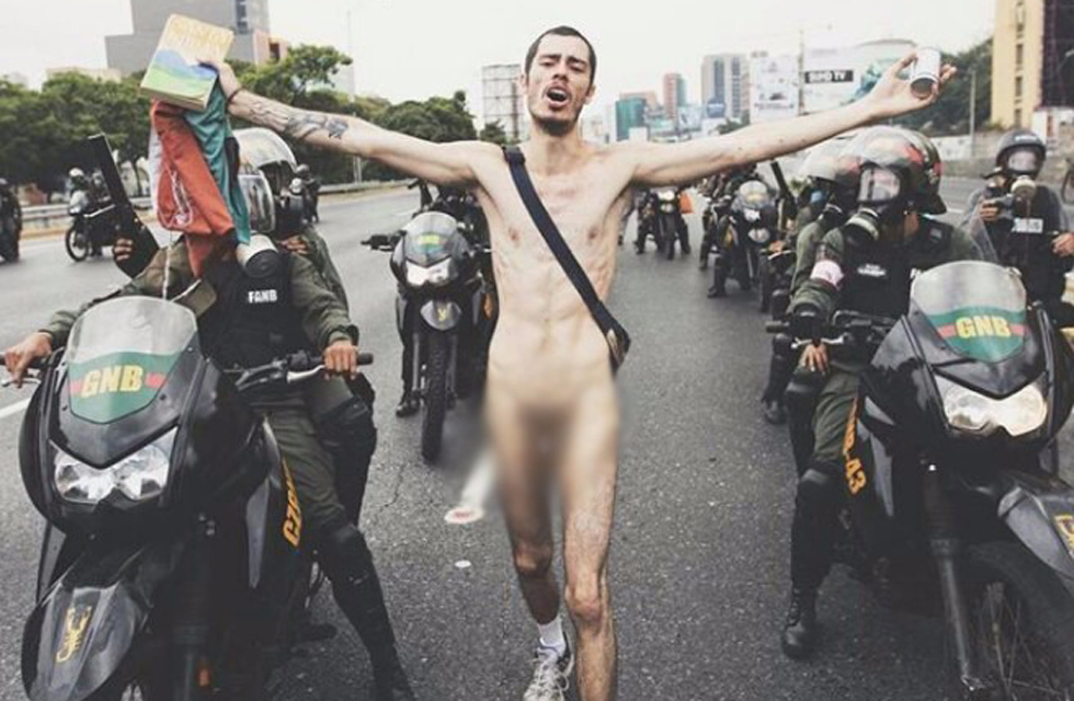 El joven completamente desnudo y con una biblia en la mano pedía a la GNB que lanzaran más lacrimógenas. Foto: donaldobarros Seguir 