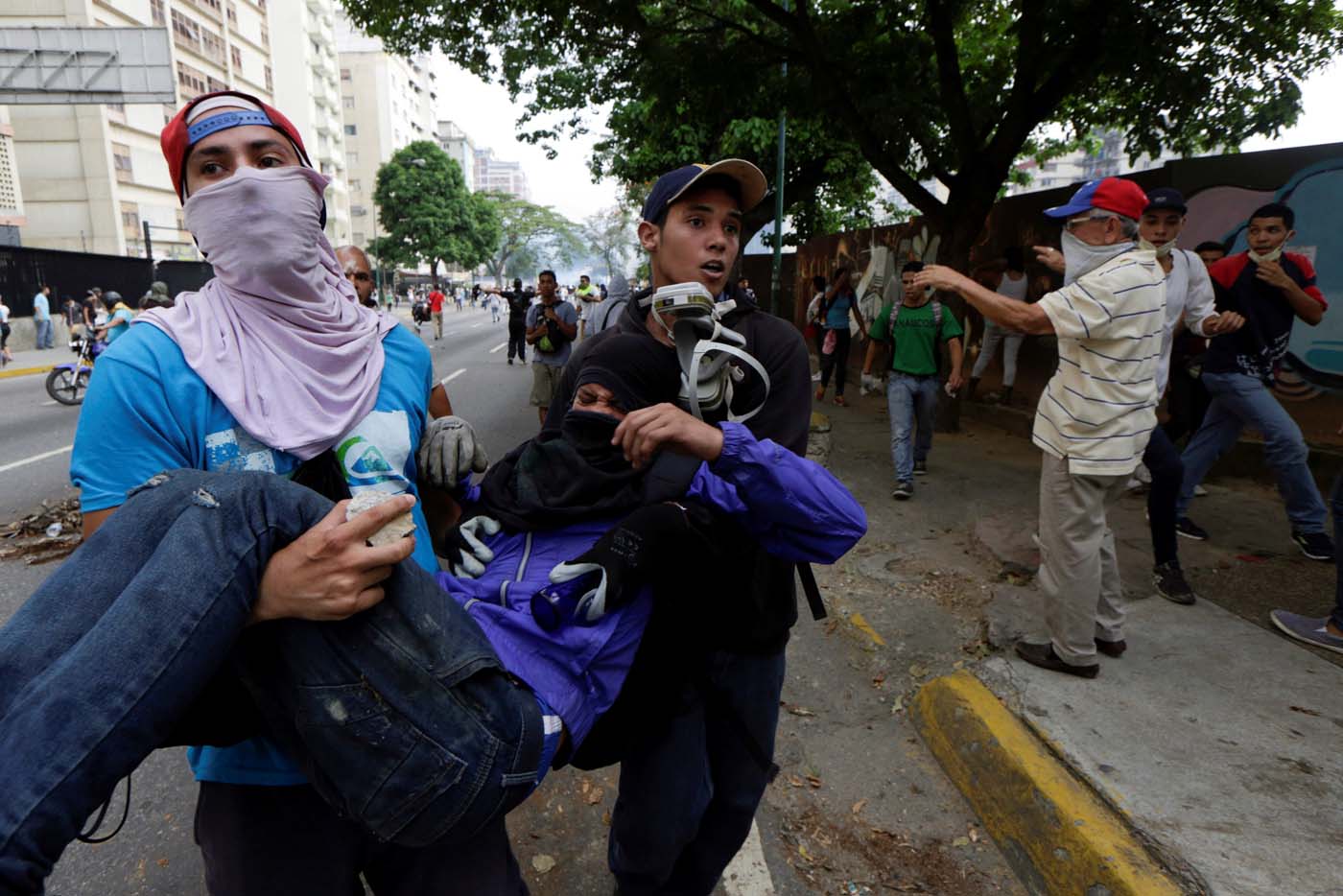 An injured demonstrator is helped during clashes with riot police while rallying against Venezuela's President Nicolas Maduro in Caracas, Venezuela, April 20, 2017. REUTERS/Marco Bello