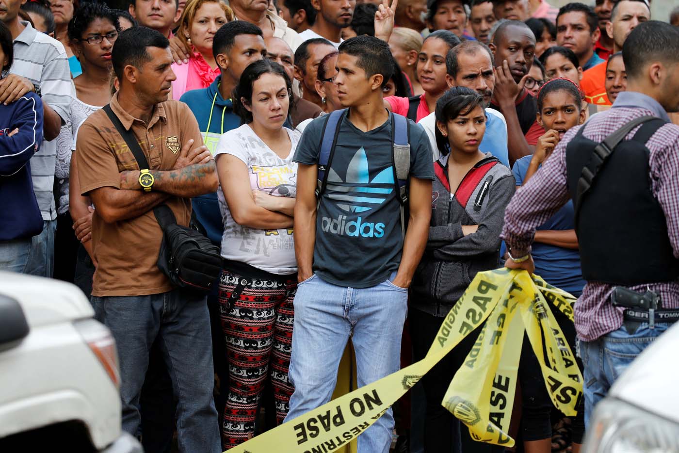 People look at police officers and criminal investigators while they collect evidence in front of a bakery, after it was looted in Caracas, Venezuela April 21, 2017. REUTERS/Carlos Garcia Rawlins