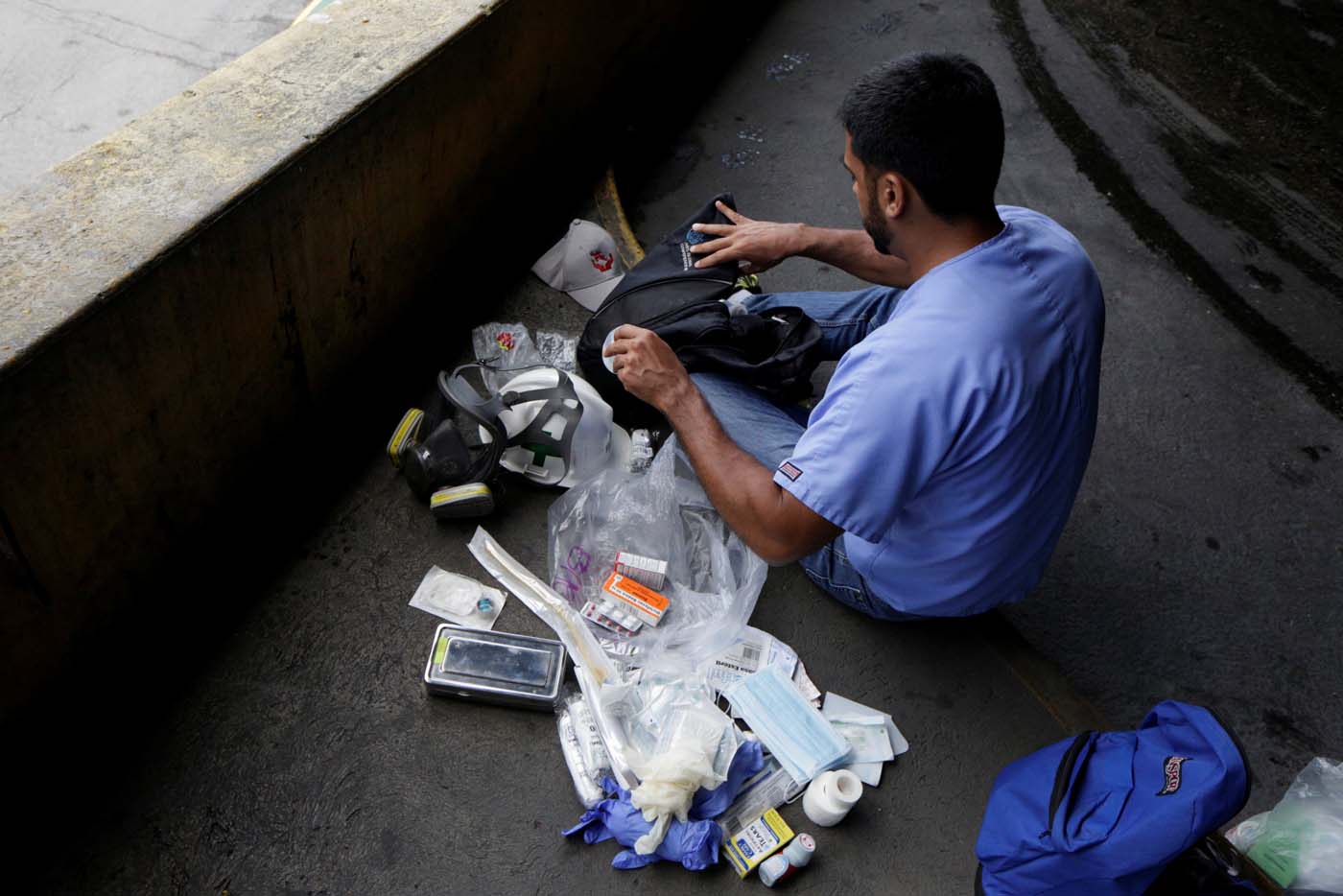 A volunteer puts medical supplies in his backpack as he gets ready for help injured demonstrators in Caracas, Venezuela April 22, 2017. Picture taken April 22, 2017. REUTERS/Marco Bello
