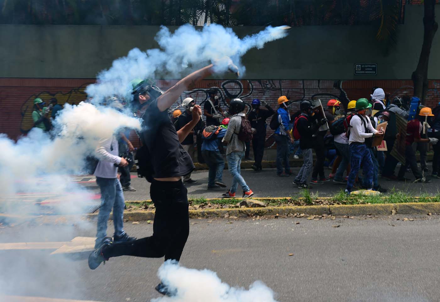 Venezuelan opposition activists clash with the police during a march against President Nicolas Maduro, in Caracas on May 1, 2017. Security forces in riot vans blocked off central Caracas Monday as Venezuela braced for pro- and anti-government May Day protests one month after a wave of deadly political unrest erupted. / AFP PHOTO / RONALDO SCHEMIDT