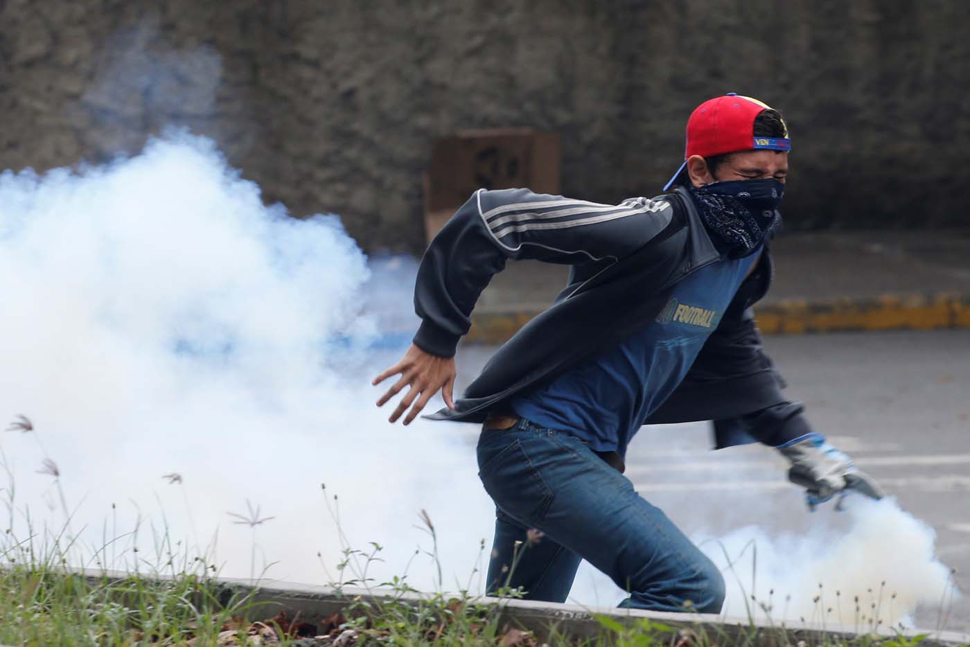 A demonstrator throws back a tear gas canister during a protest against Venezuela's President Nicolas Maduro's government in Caracas, Venezuela May 2, 2017. REUTERS/Carlos Garcia Rawlins
