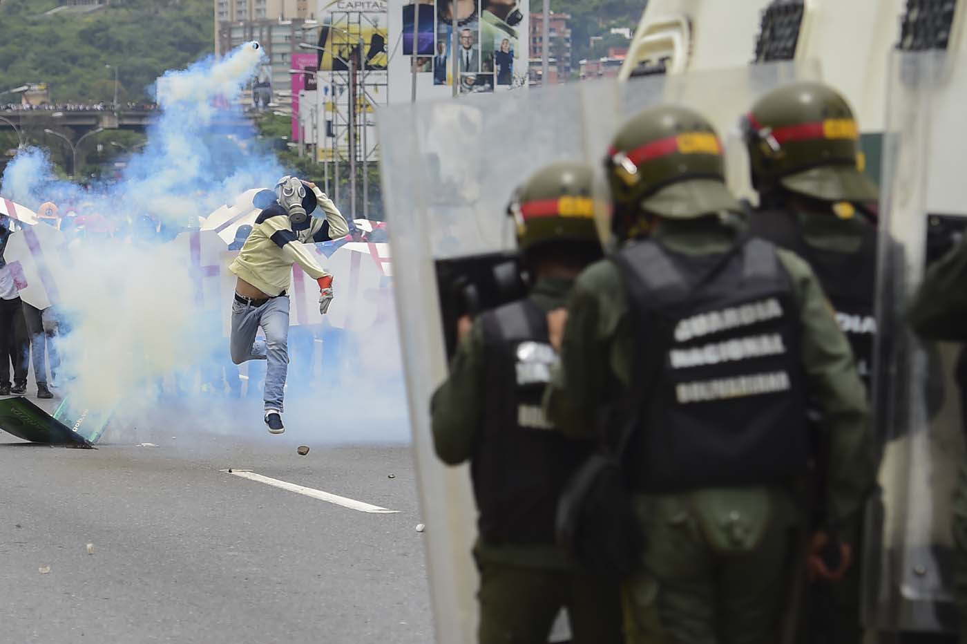 Riot police agents clash with demonstrators during a protest against Venezuelan President Nicolas Maduro, in Caracas on May 3, 2017. Venezuela's angry opposition rallied Wednesday vowing huge street protests against President Nicolas Maduro's plan to rewrite the constitution and accusing him of dodging elections to cling to power despite deadly unrest. / AFP PHOTO / RONALDO SCHEMIDT