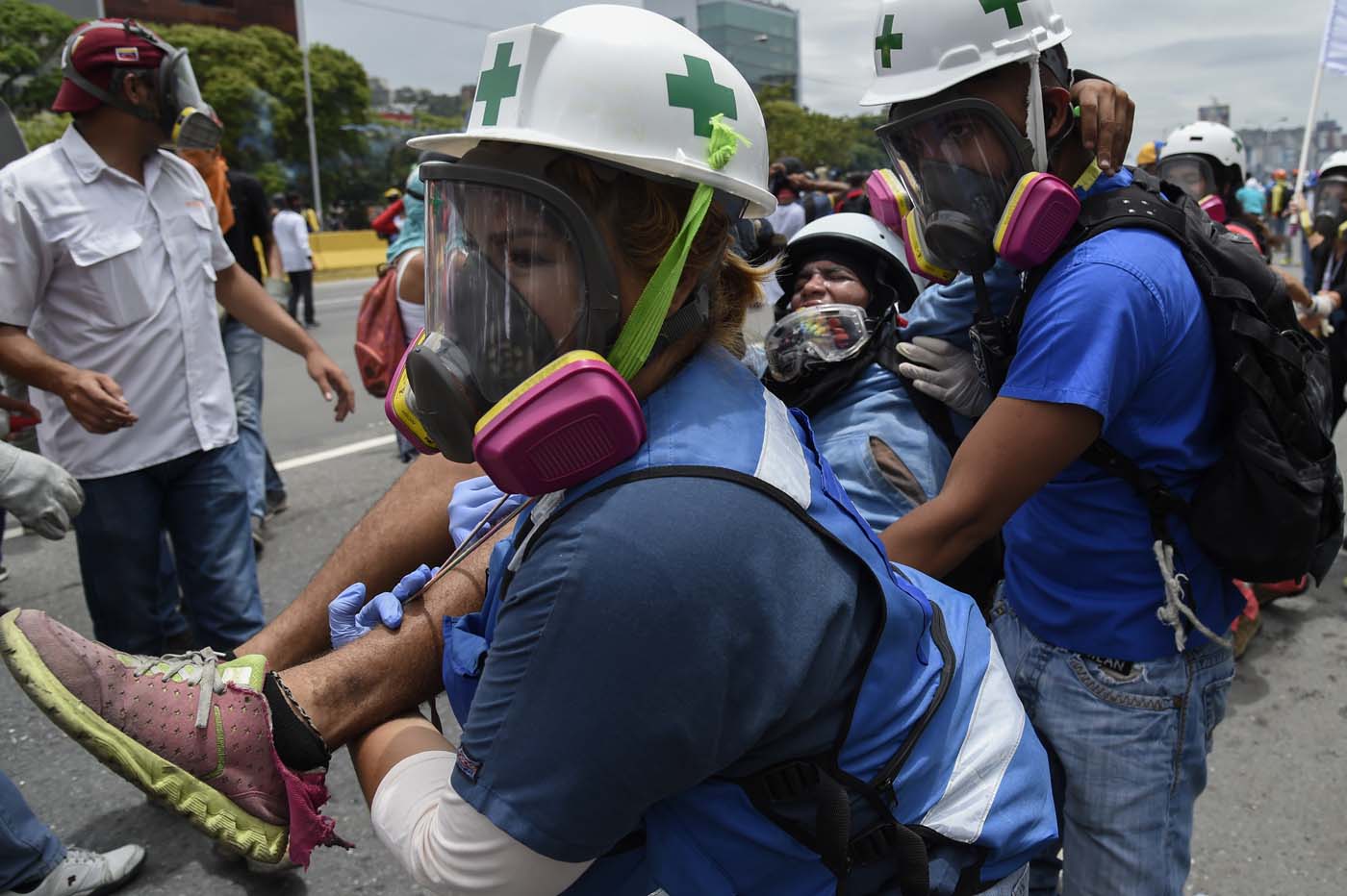 A demonstrator is attended by medical staff during a protest against Venezuelan President Nicolas Maduro, in Caracas on May 3, 2017. Venezuela's angry opposition rallied Wednesday vowing huge street protests against President Nicolas Maduro's plan to rewrite the constitution and accusing him of dodging elections to cling to power despite deadly unrest. / AFP PHOTO / JUAN BARRETO