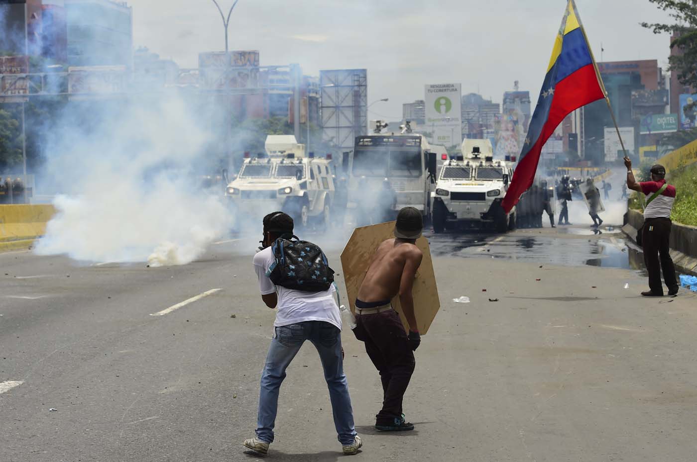 Demonstrators clash with riot police during a protest against Venezuelan President Nicolas Maduro, in Caracas on May 3, 2017. Venezuela's angry opposition rallied Wednesday vowing huge street protests against President Nicolas Maduro's plan to rewrite the constitution and accusing him of dodging elections to cling to power despite deadly unrest. / AFP PHOTO / RONALDO SCHEMIDT