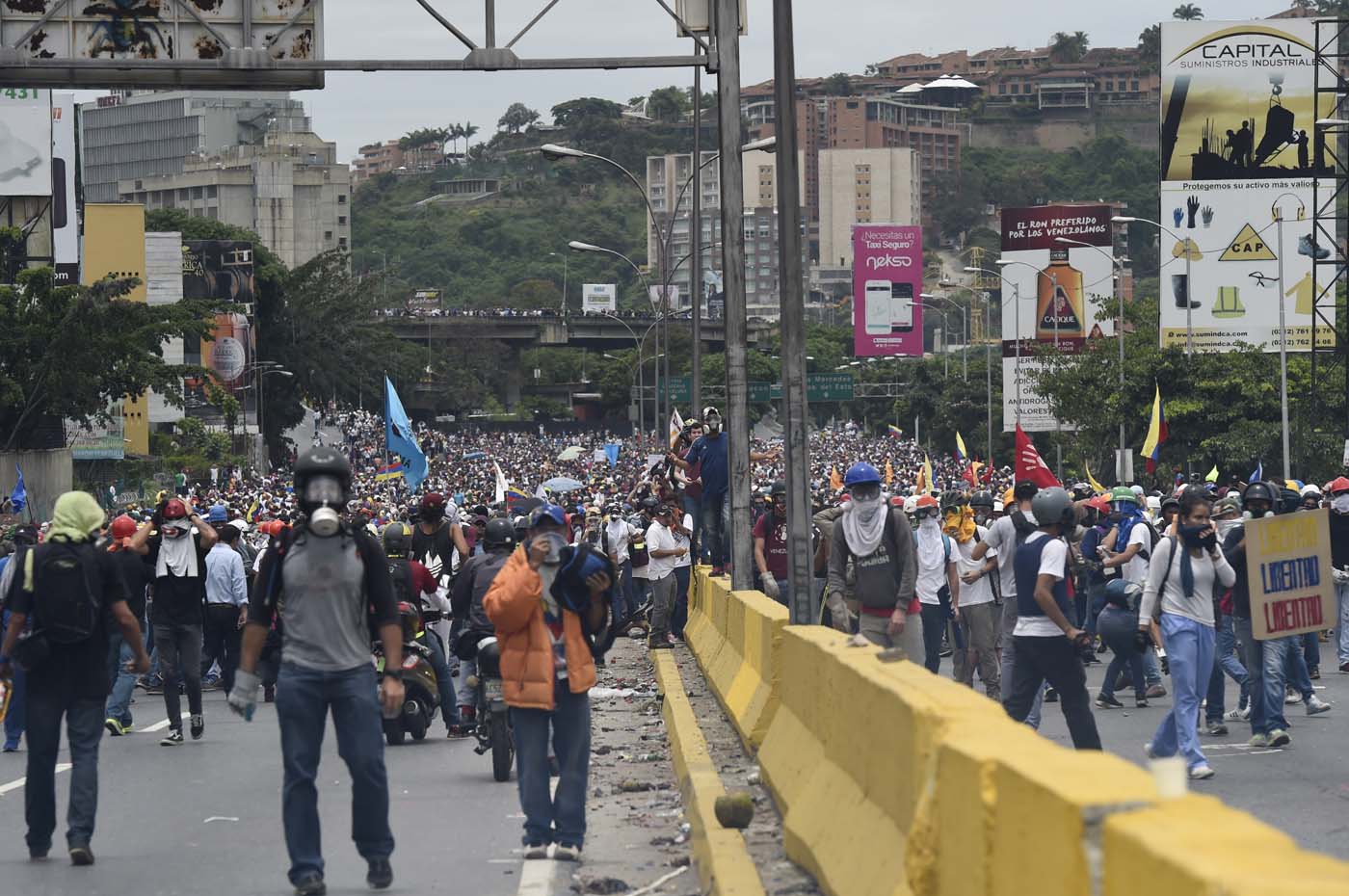 Demonstrators march along a major highway of Caracas during a protest against Venezuelan President Nicolas Maduro, on May 3, 2017. Venezuela's angry opposition rallied Wednesday vowing huge street protests against President Nicolas Maduro's plan to rewrite the constitution and accusing him of dodging elections to cling to power despite deadly unrest. / AFP PHOTO / JUAN BARRETO
