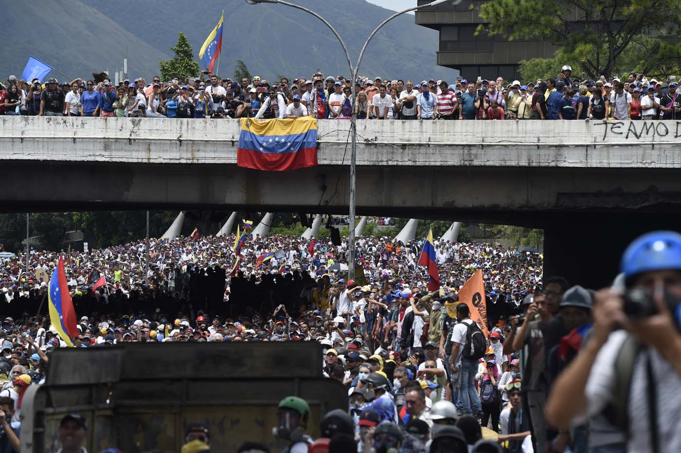 Opposition activists march during a protest against Venezuelan President Nicolas Maduro, in Caracas on May 3, 2017. Venezuela's angry opposition rallied Wednesday vowing huge street protests against President Nicolas Maduro's plan to rewrite the constitution and accusing him of dodging elections to cling to power despite deadly unrest. / AFP PHOTO / JUAN BARRETO