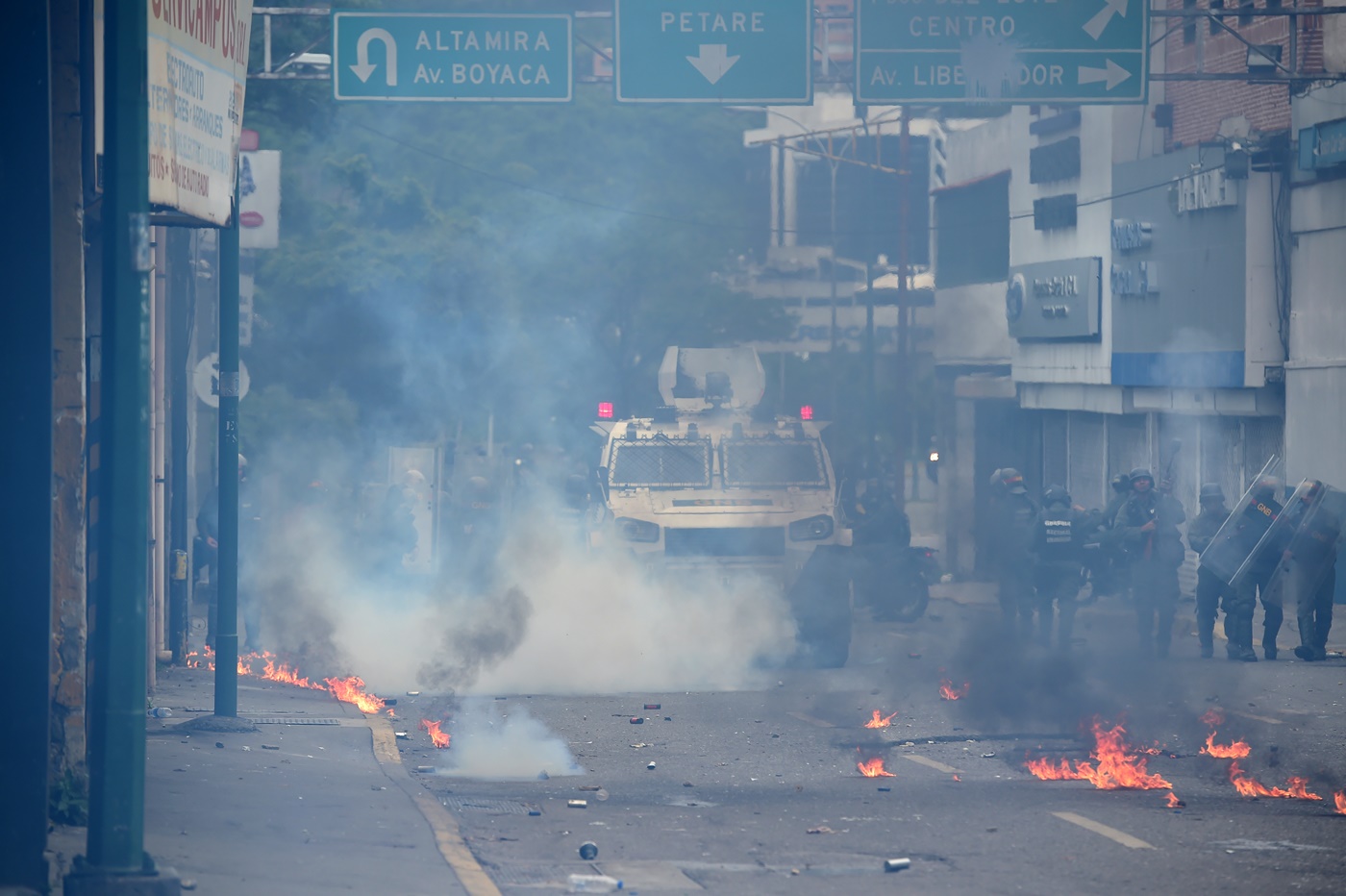 Venezuelan National Guard personnel in riot gear and supported by a riot control vehicle clash with opposition demonstrators during a protest against Venezuelan President Nicolas Maduro, in Caracas on May 3, 2017. Venezuela's angry opposition rallied Wednesday vowing huge street protests against President Nicolas Maduro's plan to rewrite the constitution and accusing him of dodging elections to cling to power despite deadly unrest. / AFP PHOTO / RONALDO SCHEMIDT