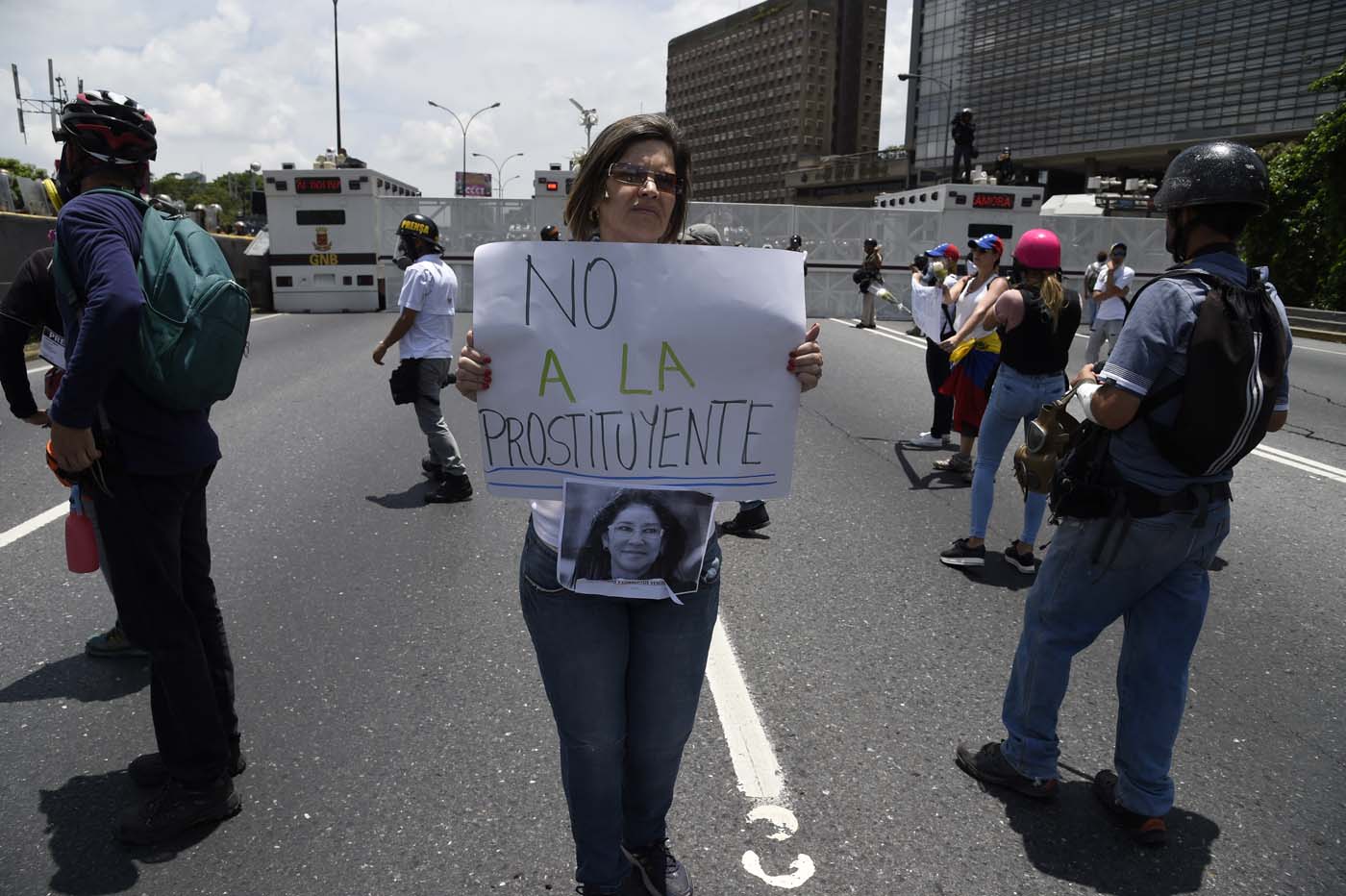 A Venezuelan opposition activist holds a sign against Venezuelan First Lady Cilia Flores during a women's march aimed to keep pressure on President Nicolas Maduro, whose authority is being increasingly challenged by protests and deadly unrest, in Caracas on May 6, 2017. The death toll since April, when the protests intensified after Maduro's administration and the courts stepped up efforts to undermine the opposition, is at least 36 according to prosecutors. / AFP PHOTO / JUAN BARRETO