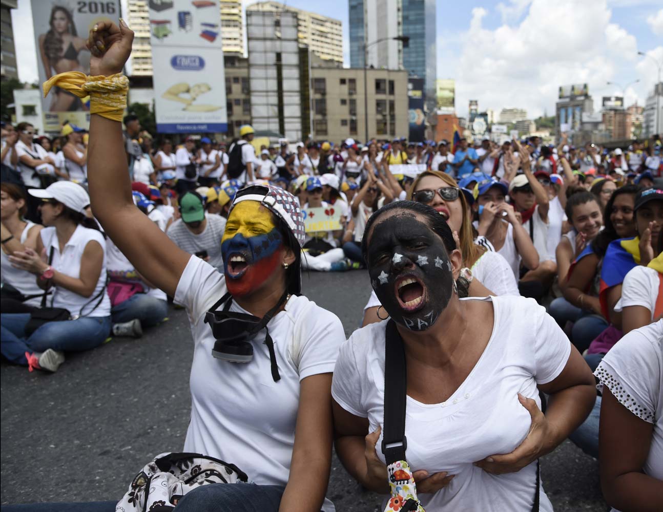 Venezuelan opposition activists take part in a women's march aimed to keep pressure on President Nicolas Maduro, whose authority is being increasingly challenged by protests and deadly unrest, in Caracas on May 6, 2017. The death toll since April, when the protests intensified after Maduro's administration and the courts stepped up efforts to undermine the opposition, is at least 36 according to prosecutors. / AFP PHOTO / JUAN BARRETO