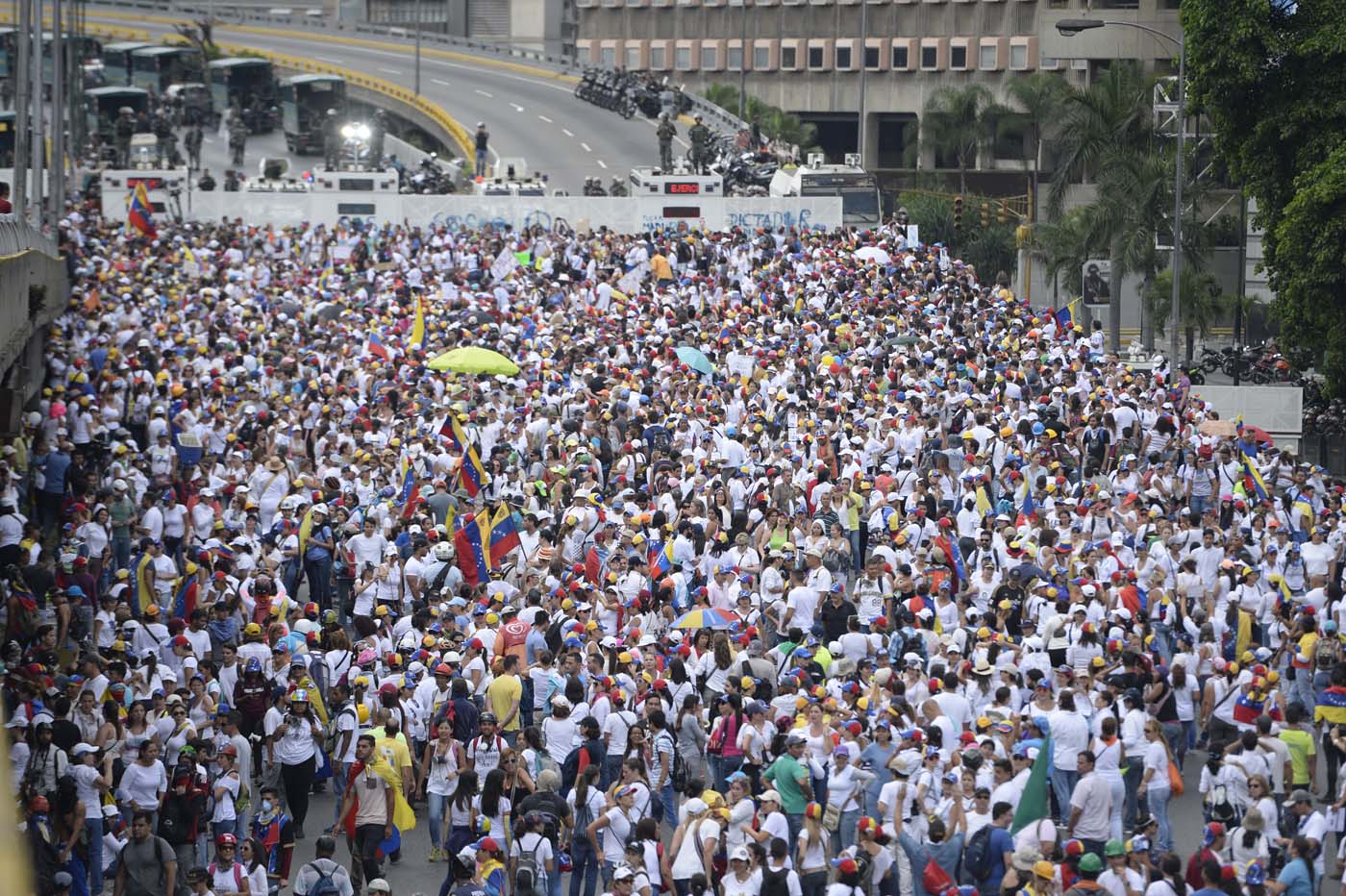 Venezuelan opposition activists take part in a women's march aimed to keep pressure on President Nicolas Maduro, whose authority is being increasingly challenged by protests and deadly unrest, in Caracas on May 6, 2017. The death toll since April, when the protests intensified after Maduro's administration and the courts stepped up efforts to undermine the opposition, is at least 36 according to prosecutors. / AFP PHOTO / FEDERICO PARRA