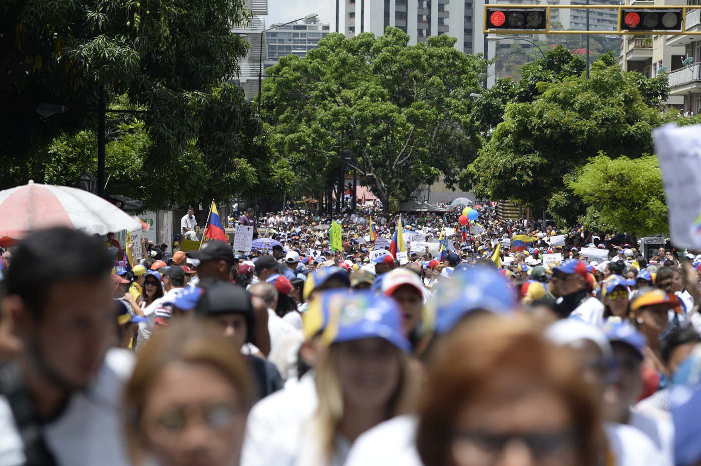 Venezuelan opposition activists take part in a women's march aimed to keep pressure on President Nicolas Maduro, whose authority is being increasingly challenged by protests and deadly unrest, in Caracas on May 6, 2017. The death toll since April, when the protests intensified after Maduro's administration and the courts stepped up efforts to undermine the opposition, is at least 36 according to prosecutors. / AFP PHOTO / FEDERICO PARRA