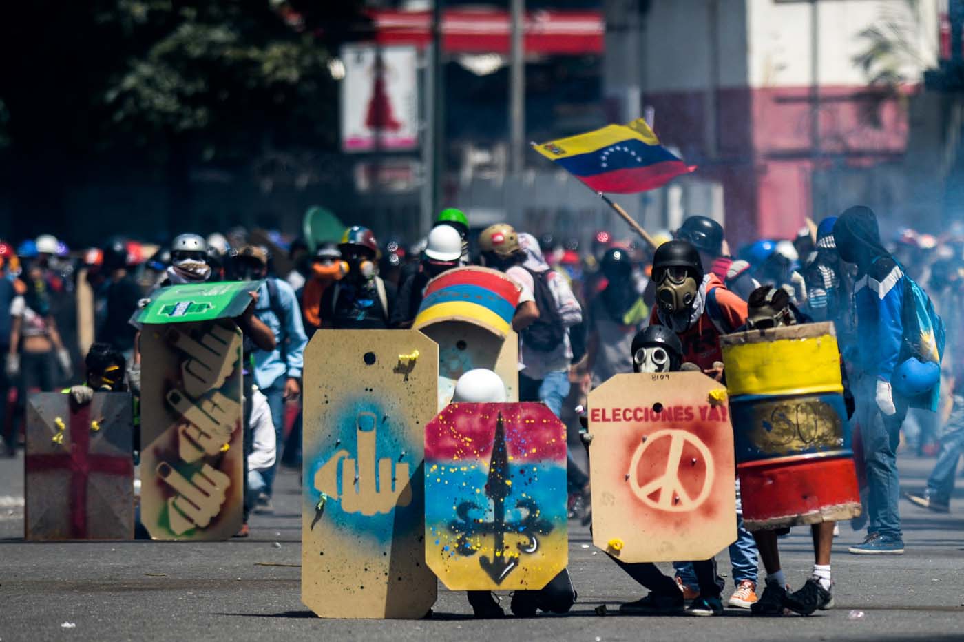 Opposition activists clash with the riot police during a demonstration against Venezuelan President Nicolas Maduro in Caracas, on May 26, 2017. Riot police in Venezuela fired tear gas and water cannon to stop anti-government protesters from marching on a key military installation Friday during the latest violence in nearly two months of unrest. / AFP PHOTO / Federico PARRA
