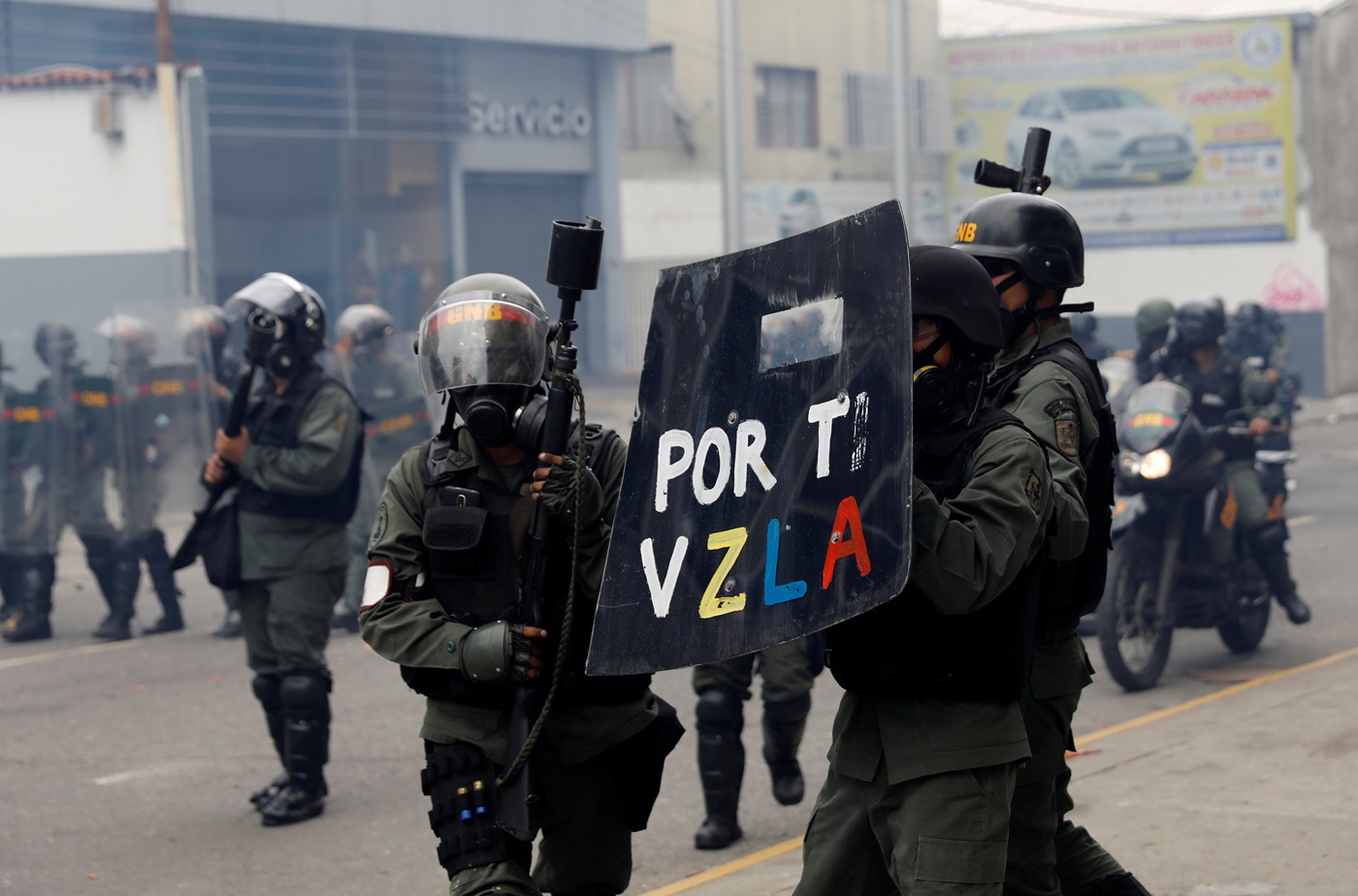 Riot police carrying a shield that reads, "For you Venezuela", take position while clashing with opposition supporters rallying against President Nicolas Maduro in Caracas, Venezuela May 3, 2017. REUTERS/Carlos Garcia Rawlins