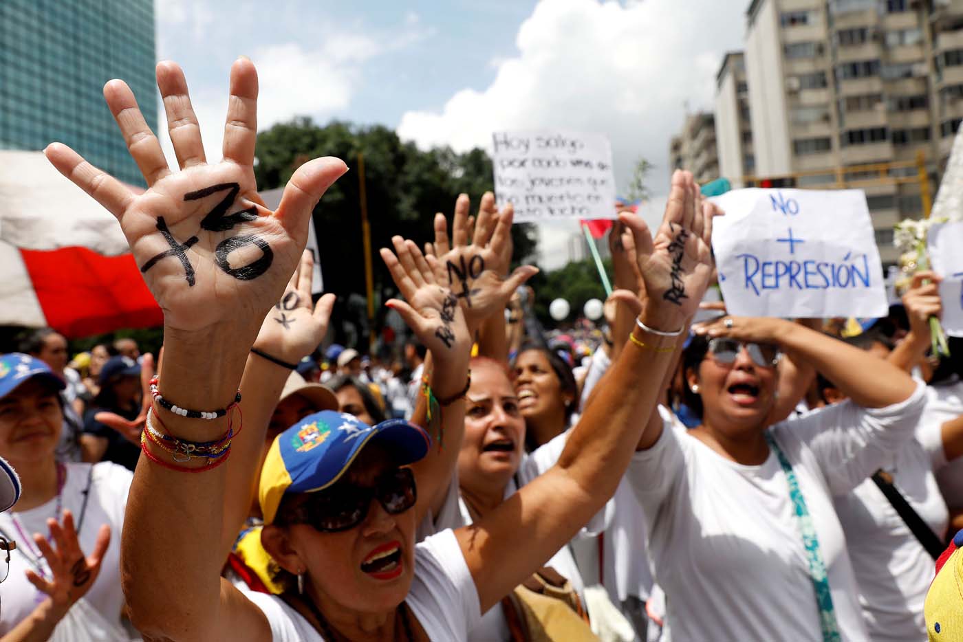 Women lift their hands as they attend a women's march to protest against President Nicolas Maduro's government in Caracas, Venezuela May 6, 2017. REUTERS/Carlos Garcia Rawlins