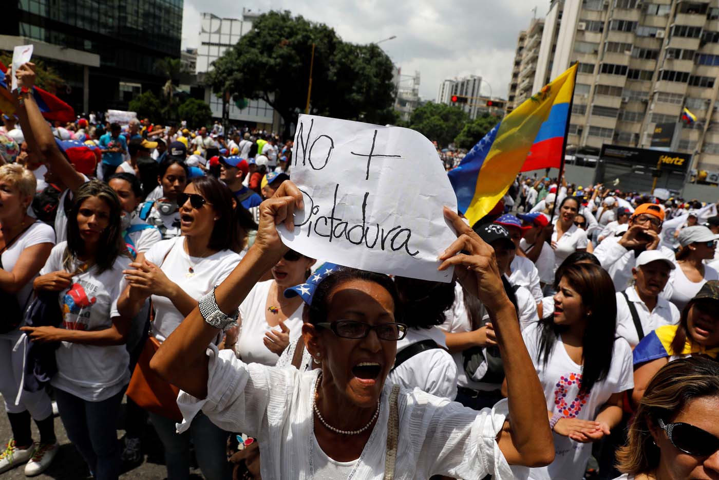 A woman holds up a placard that reads "No more dictatorship" during a women's march to protest against President Nicolas Maduro's government in Caracas, Venezuela, May 6, 2017. REUTERS/Carlos Garcia Rawlins