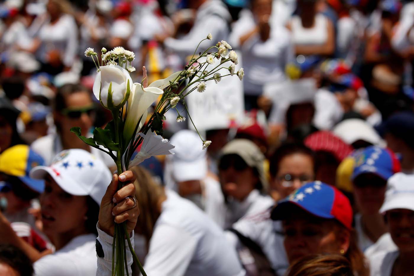 A demonstrator holds up flowers during a women's march to protest against President Nicolas Maduro's government in Caracas, Venezuela, May 6, 2017. REUTERS/Carlos Garcia Rawlins