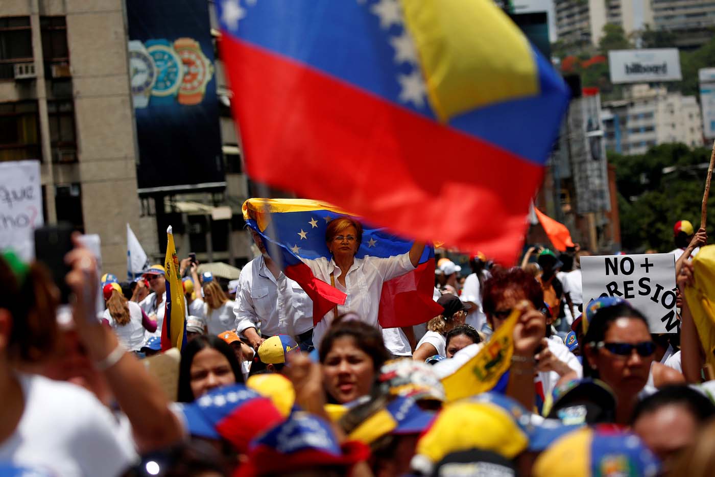 Demonstrators hold Venezuelan flags as they attend a women's march to protest against President Nicolas Maduro's government in Caracas, Venezuela, May 6, 2017. REUTERS/Carlos Garcia Rawlins