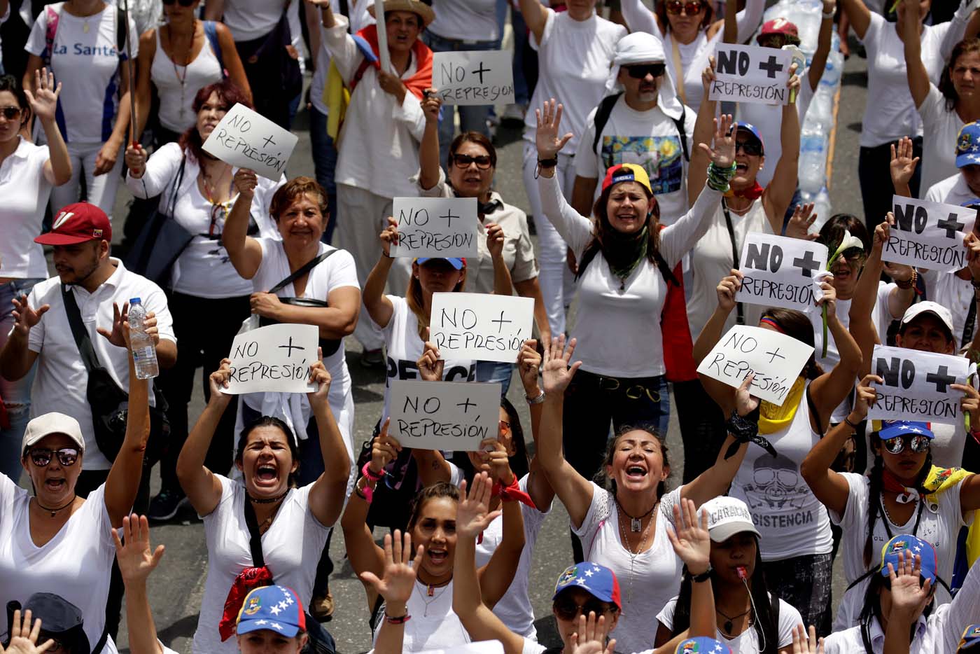 Demonstrators hold placards that read "No more repression" during a women's march to protest against President Nicolas Maduro's government in Caracas, Venezuela, May 6, 2017. REUTERS/Marco Bello