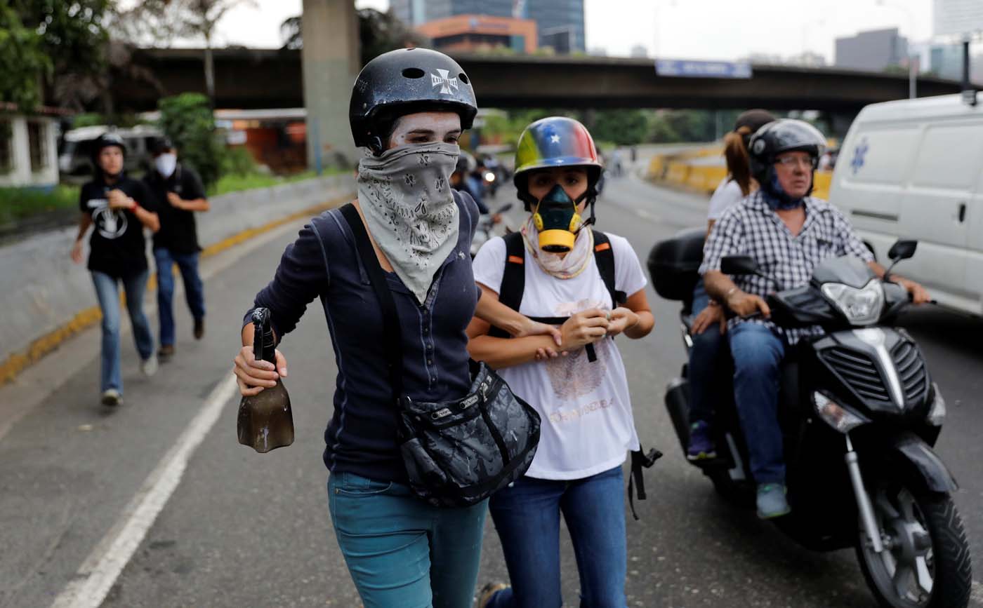 Opposition supporters run away while rallying against Venezuelan President Nicolas Maduro in Caracas, Venezuela, May 8, 2017. REUTERS/Carlos Garcia Rawlins
