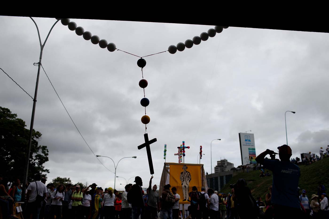 Opposition supporters hang a giant rosary beads from a bridge as they block a highway, during a protest against Venezuelan President Nicolas Maduro's government in Caracas, Venezuela May 15, 2017. REUTERS/Carlos Garcia Rawlins