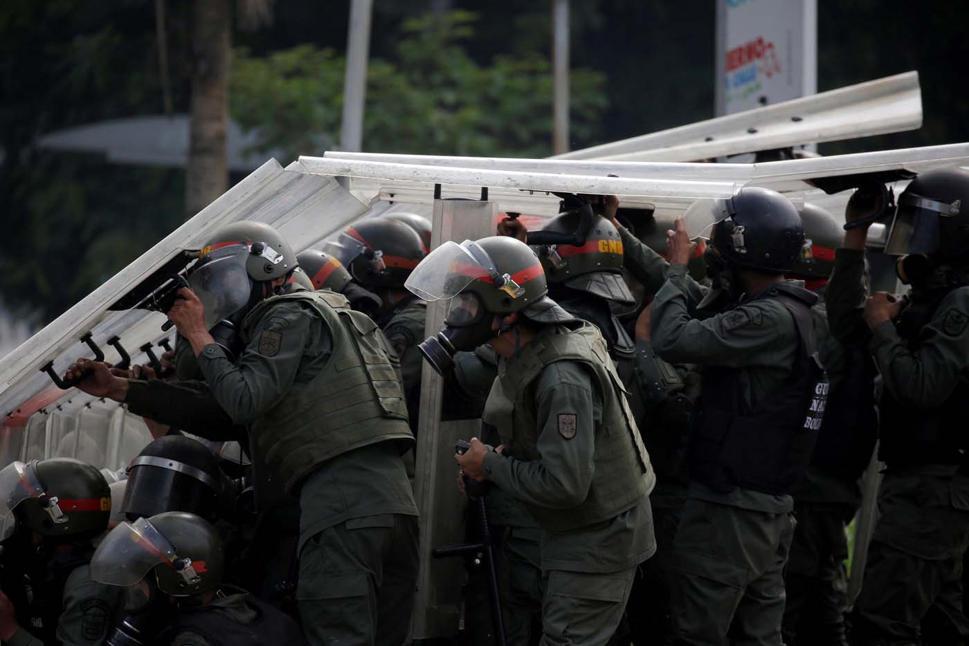Riot security forces take cover while clashing with demonstrators rallying against President Nicolas Maduro in Caracas, Venezuela, May 24, 2017. REUTERS/Carlos Barria