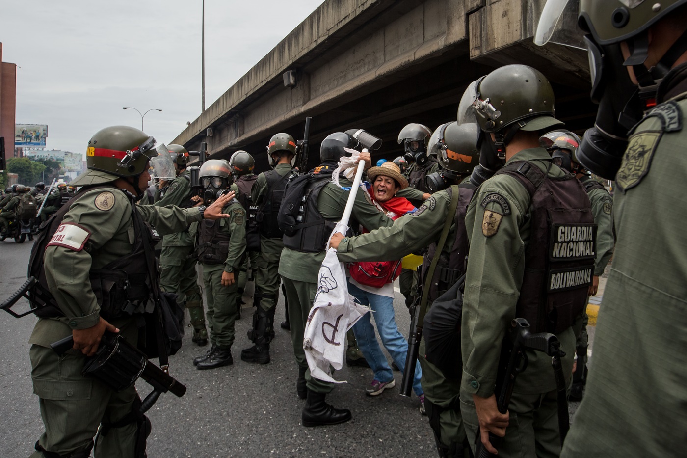 CAR014. CARACAS (VENEZUELA), 03/05/2017 - Militares retiran a una mujer (c) que bloqueaba el paso de una tanqueta de la Guardia Nacional durante una manifestación encabezada por diputados opositores hoy, miércoles 3 de mayo de 2017, en Caracas (Venezuela). La Guardia Nacional Bolivariana (GNB, policía militarizada) de Venezuela dispersó hoy con gases lacrimógenos una movilización opositora en el este de Caracas que pretendía llegar hasta la sede de la Asamblea Nacional (AN, Parlamento), ubicada en el centro de la capital. EFE/MIGUEL GUTIERREZ