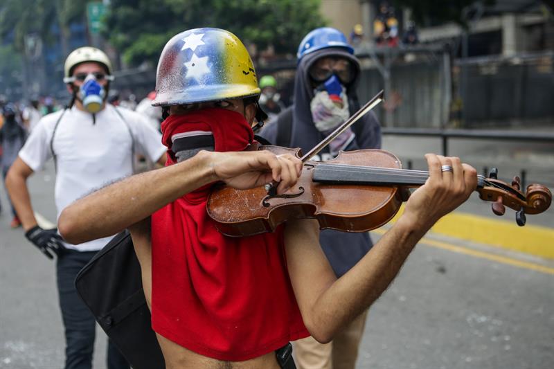 Un manifestante toca violín en una manifestación hoy, lunes 8 de mayo de 2017, en Caracas (Venezuela). Foto: EFE/CRISTIAN HERNÁNDEZ