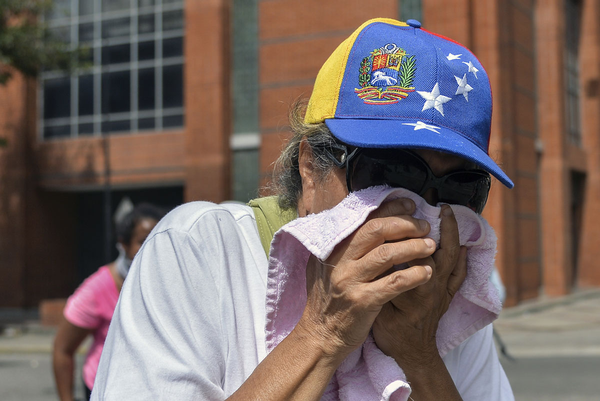 An opposition demonstrator is affected by tear gas in clashes with the riot police during the "Towards Victory" protest against the government of Nicolas Maduro, in Caracas on June 10, 2017. Clashes at near daily protests by demonstrators calling for Maduro to quit have left 66 people dead since April 1, prosecutors say. / AFP PHOTO / LUIS ROBAYO