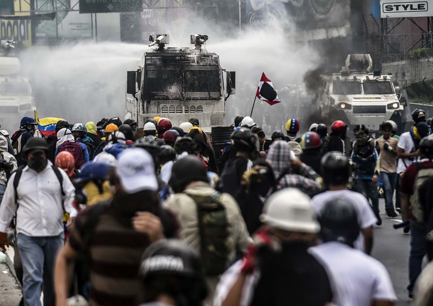 Opposition activists clash with riot police during a demonstration against the government of President Nicolas Maduro along the Francisco Fajardo highway in Caracas on June 19, 2017. Near-daily protests against President Nicolas Maduro began on April 1, with demonstrators demanding his removal and the holding of new elections. The demonstrations have often turned violent with 73 people killed and more than 1,000 injured so far, prosecutors say, and more than 3,000 arrested, according to the NGO Forum Penal. / AFP PHOTO / Juan BARRETO