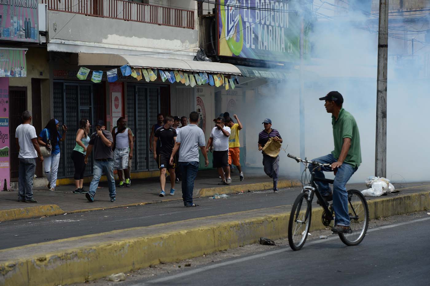 EDITORS NOTE: Graphic content / Police fire tear gas to scatter the crowd during lootings in Maracay, Venezuela on June 27, 2017. / AFP PHOTO / Federico Parra / GRAPHIC CONTENT