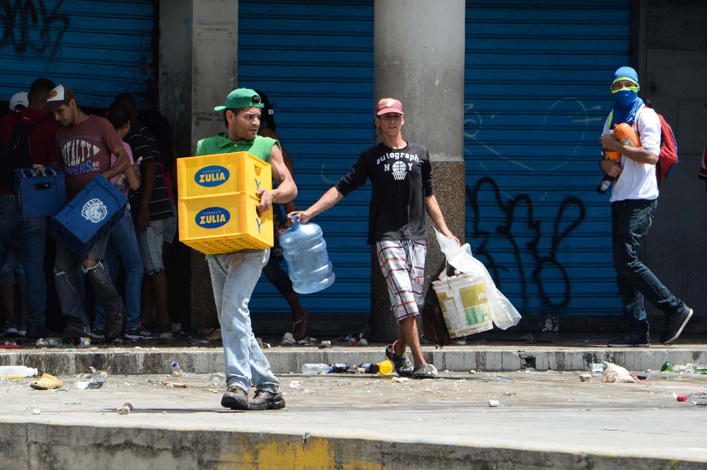 People carry stolen merchandise during lootings in Maracay, Aragua State, Venezuela on June 27, 2017. A political and economic crisis in the oil-producing country has spawned often violent demonstrations by protesters demanding President Nicolas Maduro's resignation and new elections. The unrest has left 76 people dead since April 1. / AFP PHOTO / Federico PARRA
