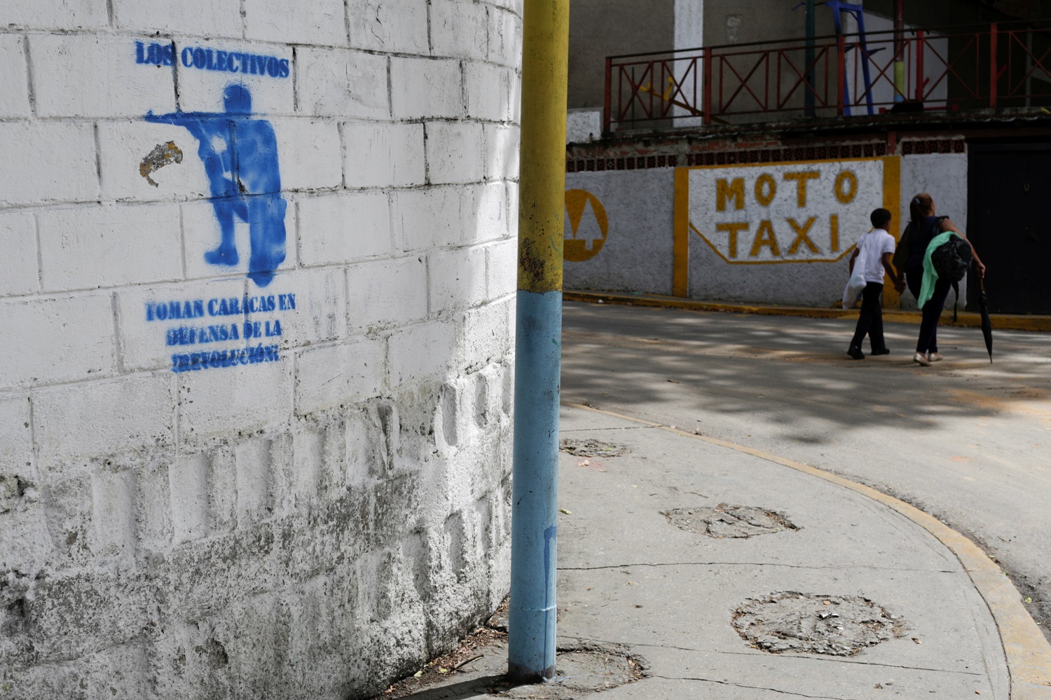 Un graffiti con la silueta de un hombre con un arma que dice "Los colectivos toman Caracas en defensa de la revolución" se ve en una calle del barrio de los 23 de Enero en Caracas, Venezuela el 19 de mayo de 2017. Foto tomada el 19 de mayo de 2017 REUTERS / Marco Bello