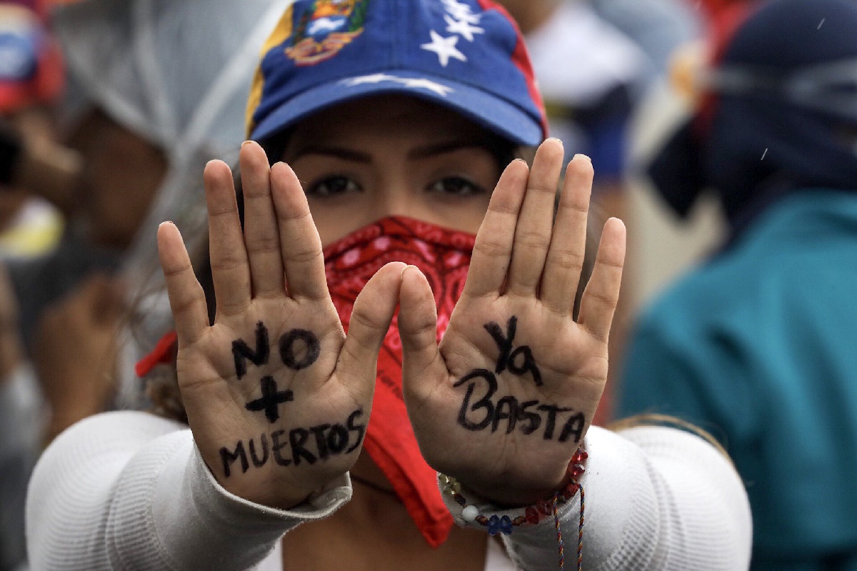 CAR32. CARACAS (VENEZUELA), 24/06/2017.- Una mujer muestra un mensaje escrito en las palmas de sus manos durante una manifestación denominada "Venezuela le da un mensaje a la FAN (Fuerza Armada)" hoy, sábado 24 de junio de 2017, en Caracas (Venezuela). La oposición venezolana se moviliza hoy hasta las bases militares en Caracas y varios estados del país, mientras el chavismo marcha para conmemorar los 196 años de la Batalla de Carabobo, una acción militar decisiva en la independencia del país caribeño, y por el Día del Ejército Bolivariano. EFE/Miguel Gutiérrez