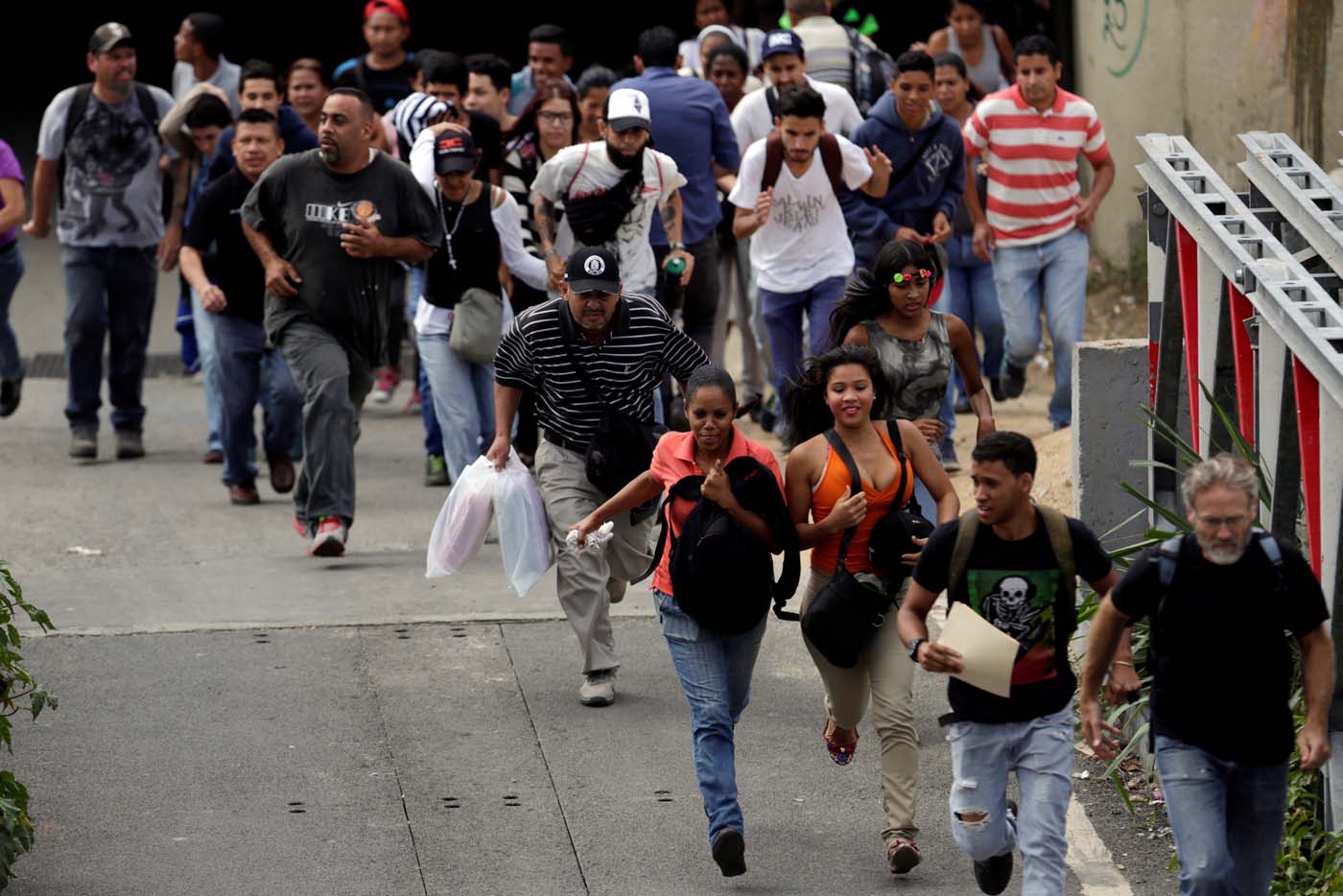 People run during during clashes with security forces at a rally against Venezuelan President Nicolas Maduro's government in Caracas, Venezuela, July 6, 2017. REUTERS/Marco Bello